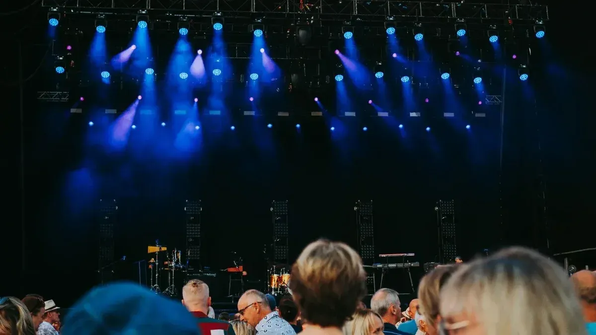 Night concert scene with audience, stage, and colorful lighting effects.
