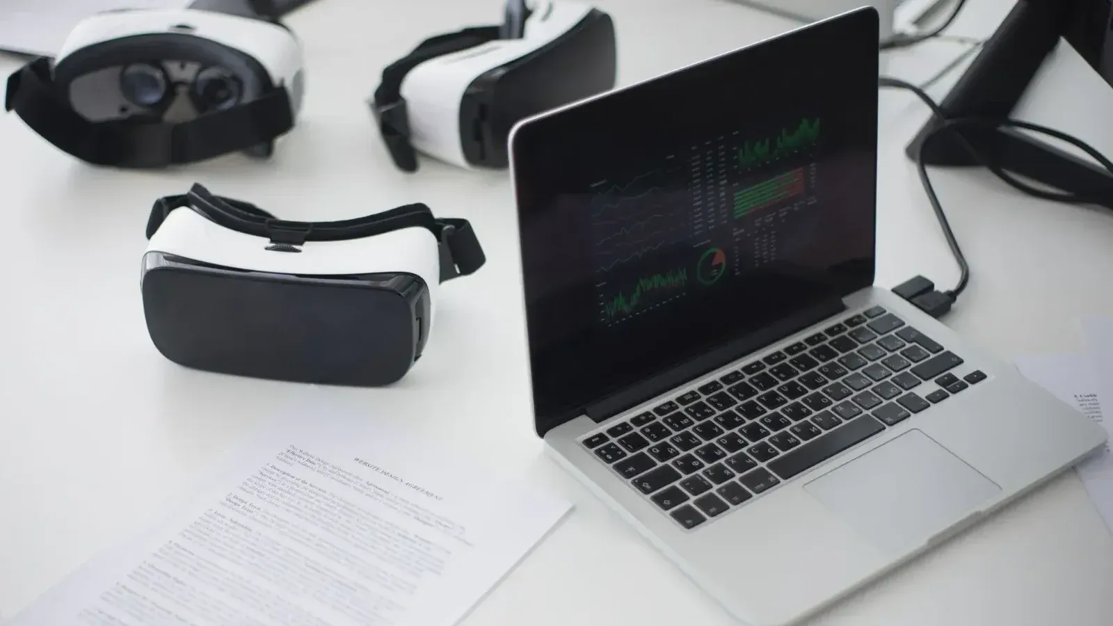 Espacio de trabajo moderno con auriculares portátiles y VR, ideal para temas tecnológicos.