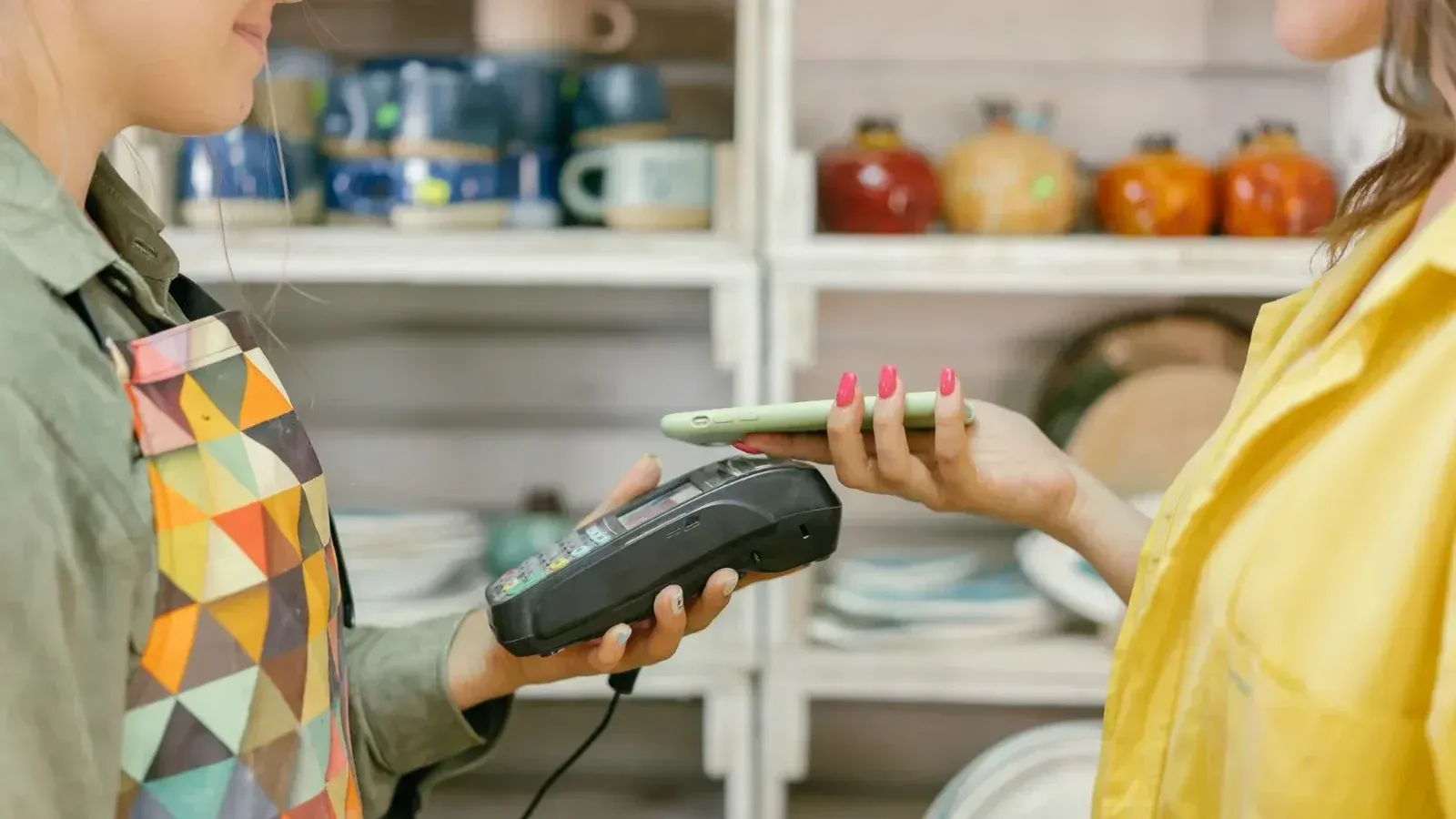 Un cliente realiza un pago sin efectivo usando un teléfono inteligente en una tienda minorista. La tecnología moderna cumple con la comodidad.