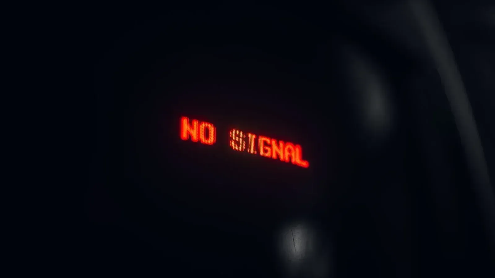 A red LED display indicating 'No Signal' in a dark setting, conveying a tech warning.