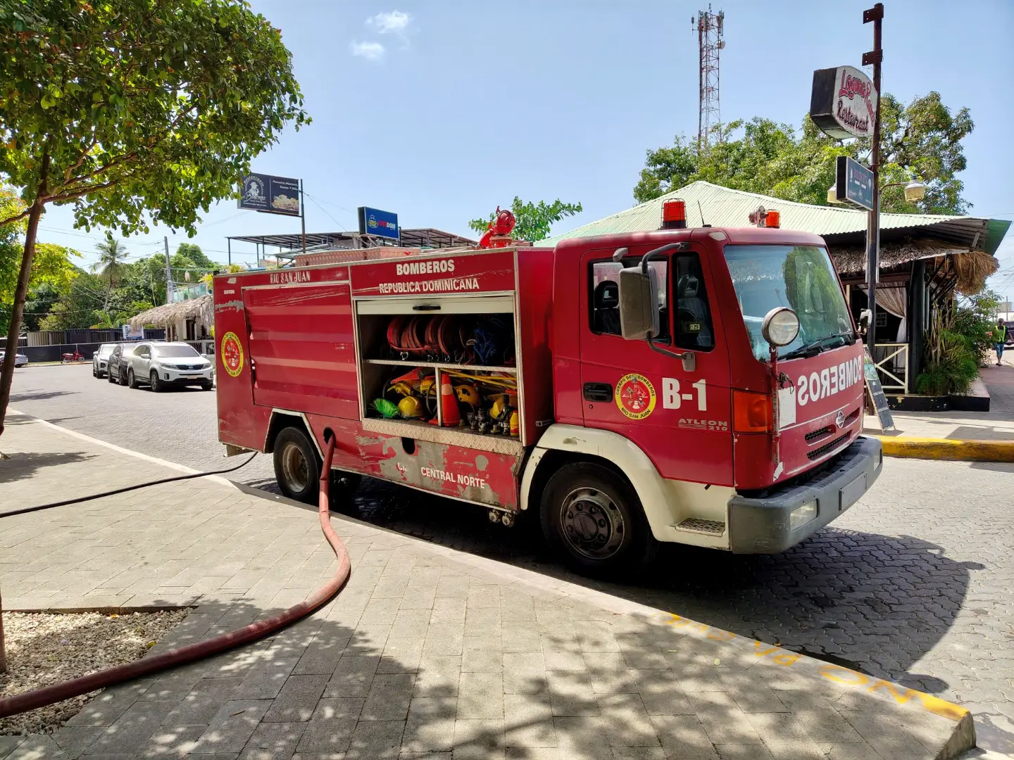 Bright red fire truck on sunny Rio San Juan street in Dominican Republic.