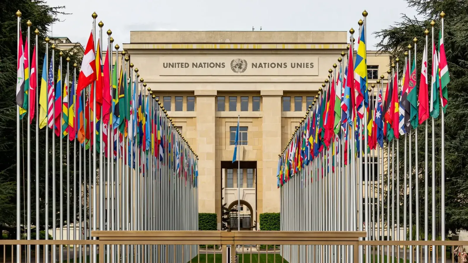 View of the United Nations Office in Geneva adorned with flags of various countries.