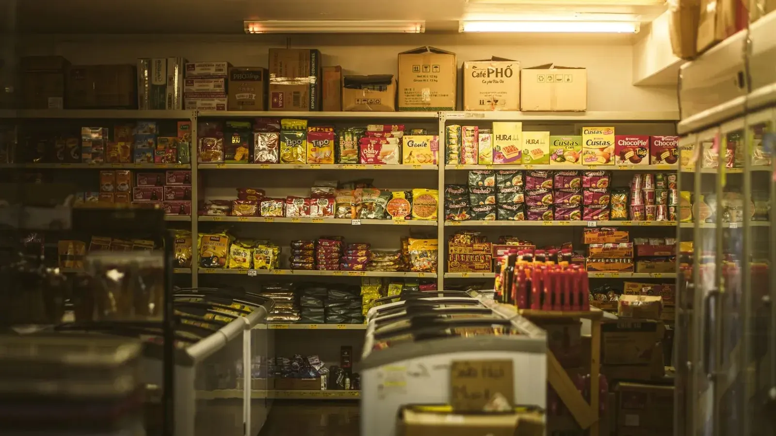 Estante repleto de diversos bocadillos y comestibles asiáticos en un acogedor entorno de tienda.