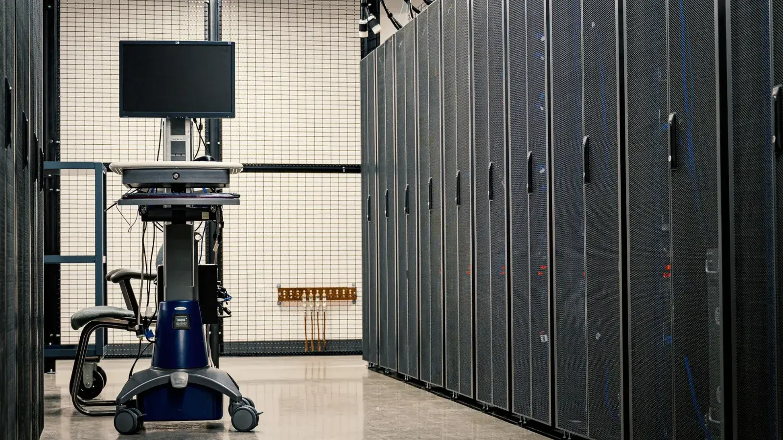 Contemporary computer on support between telecommunication racks and cabinets in modern data center