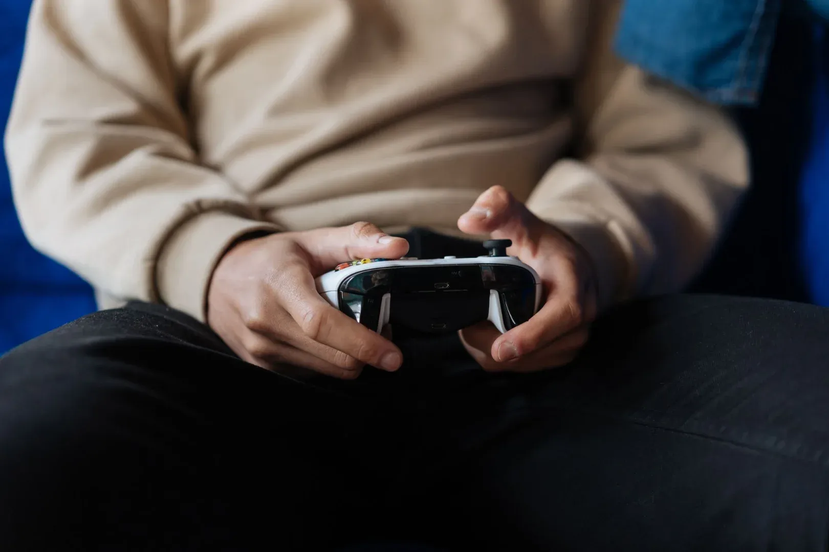 Close-up of a person holding a game controller, immersed in a video game.