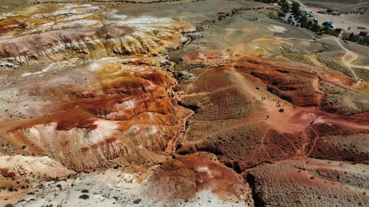 A stunning aerial view of colorful geological formations resembling a Martian landscape.