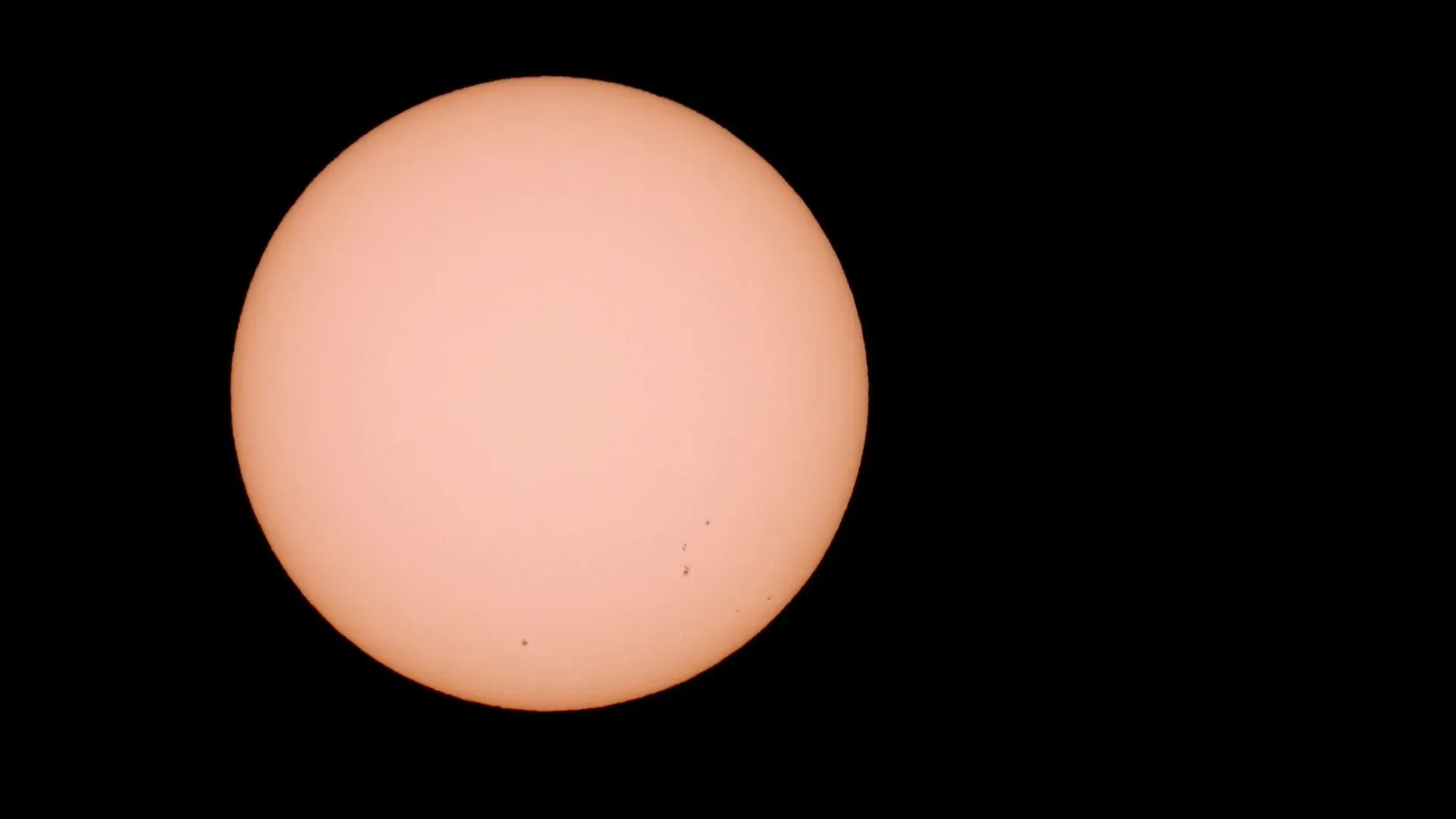 Detailed photograph of the sun showcasing visible sunspots against a black background.