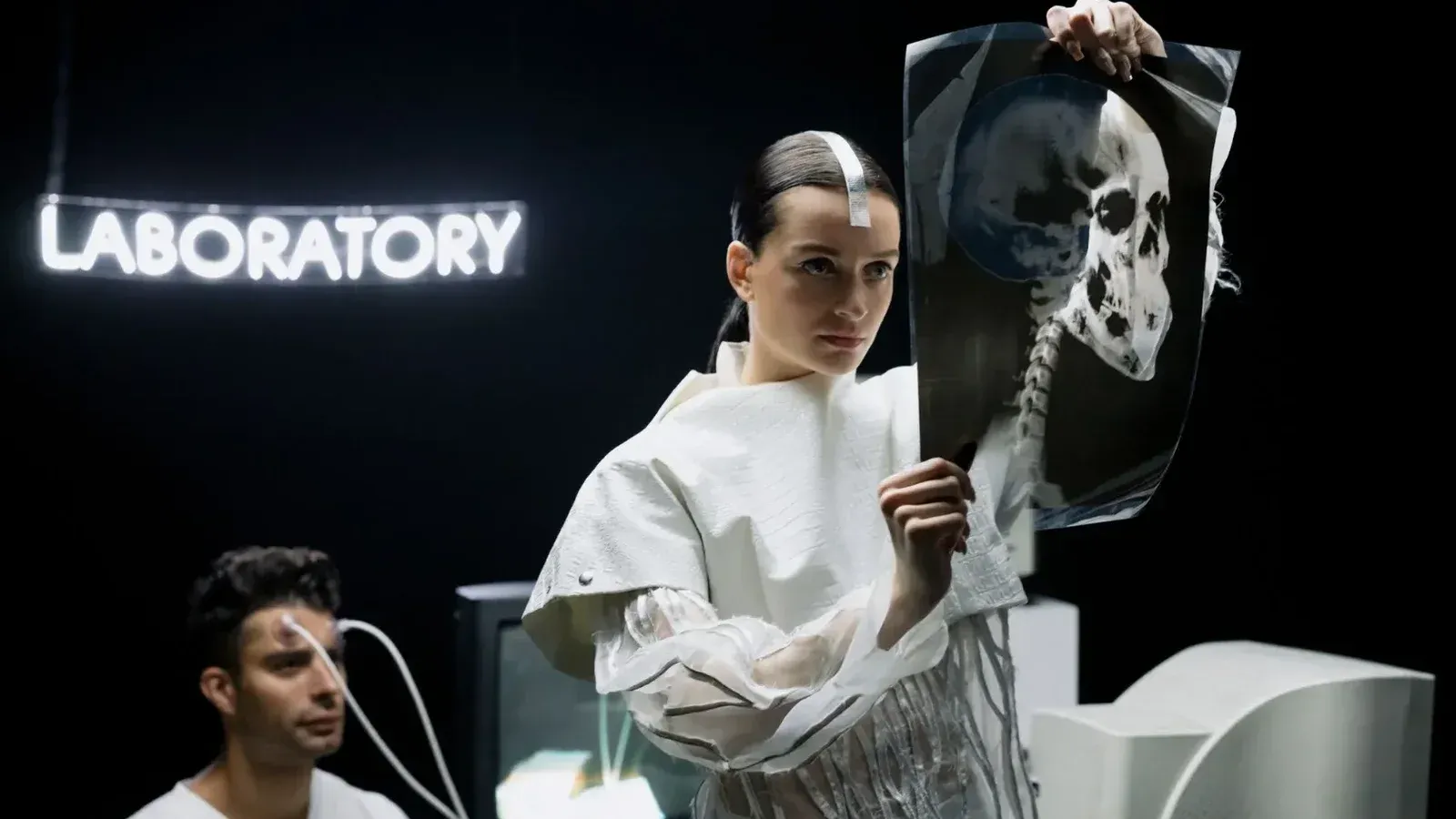 A woman examines an X-ray in a futuristic laboratory setting with neon lights.