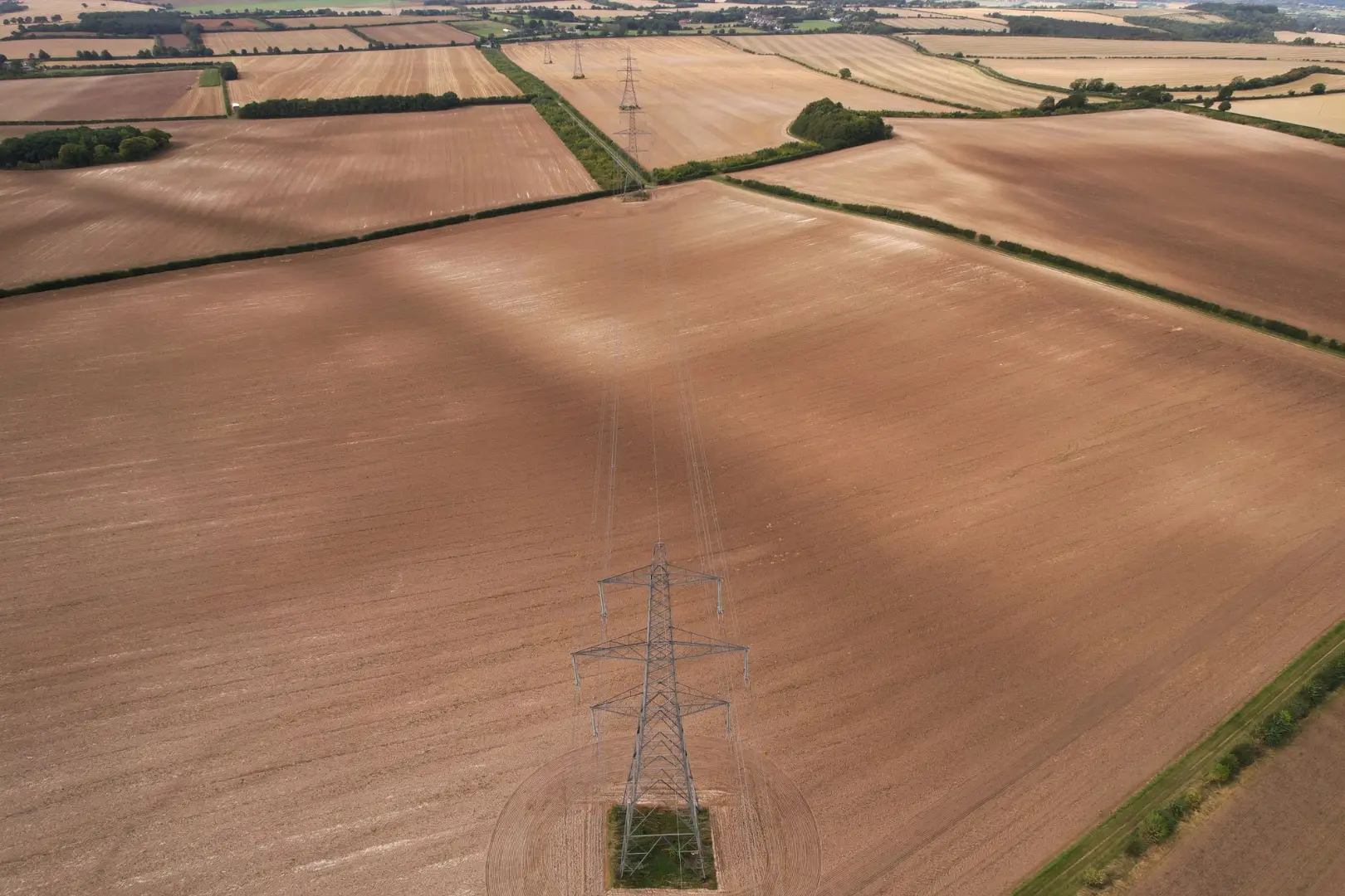Drone shot of cropland in Central Bedfordshire, England with transmission towers.