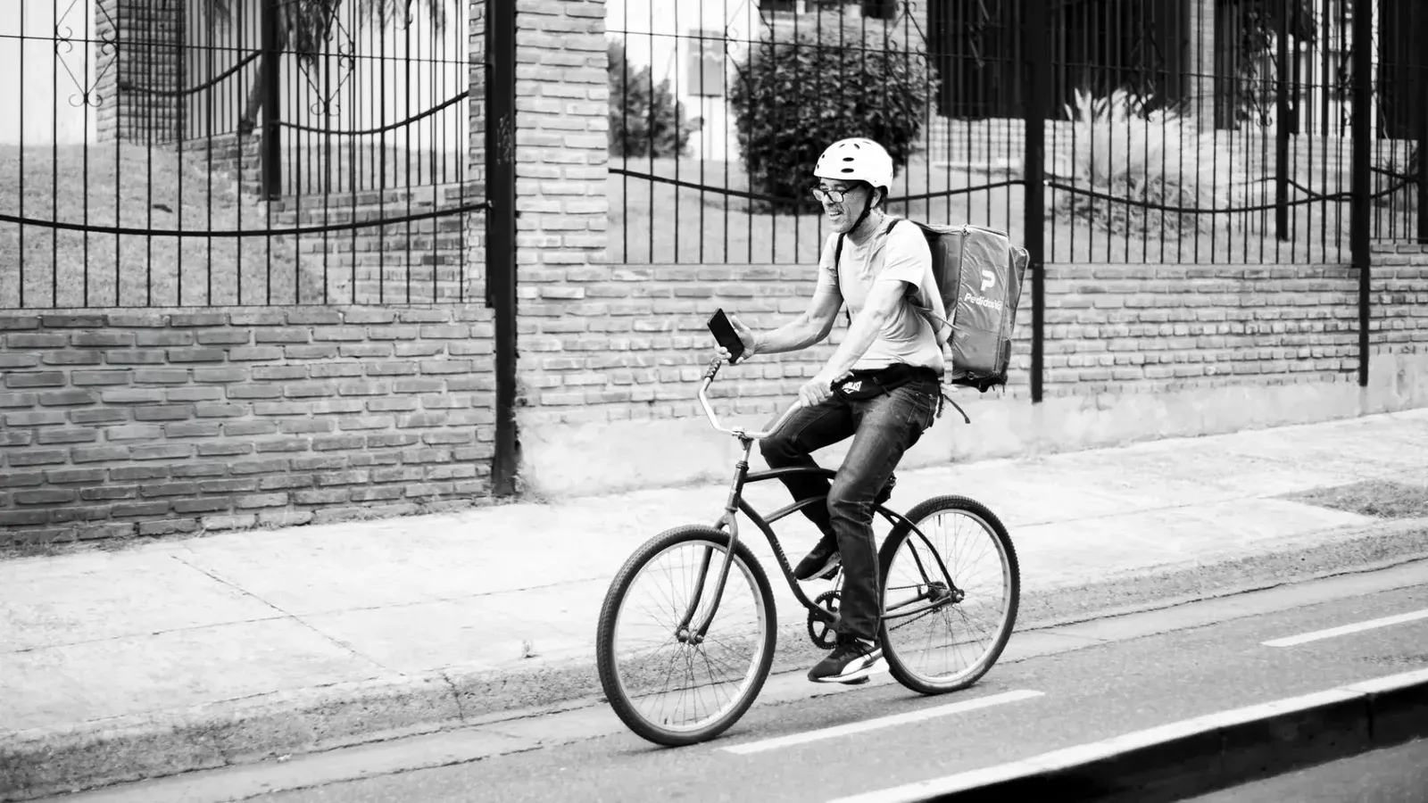 Black and white photo of a bicyclist in Buenos Aires, showcasing urban lifestyle.