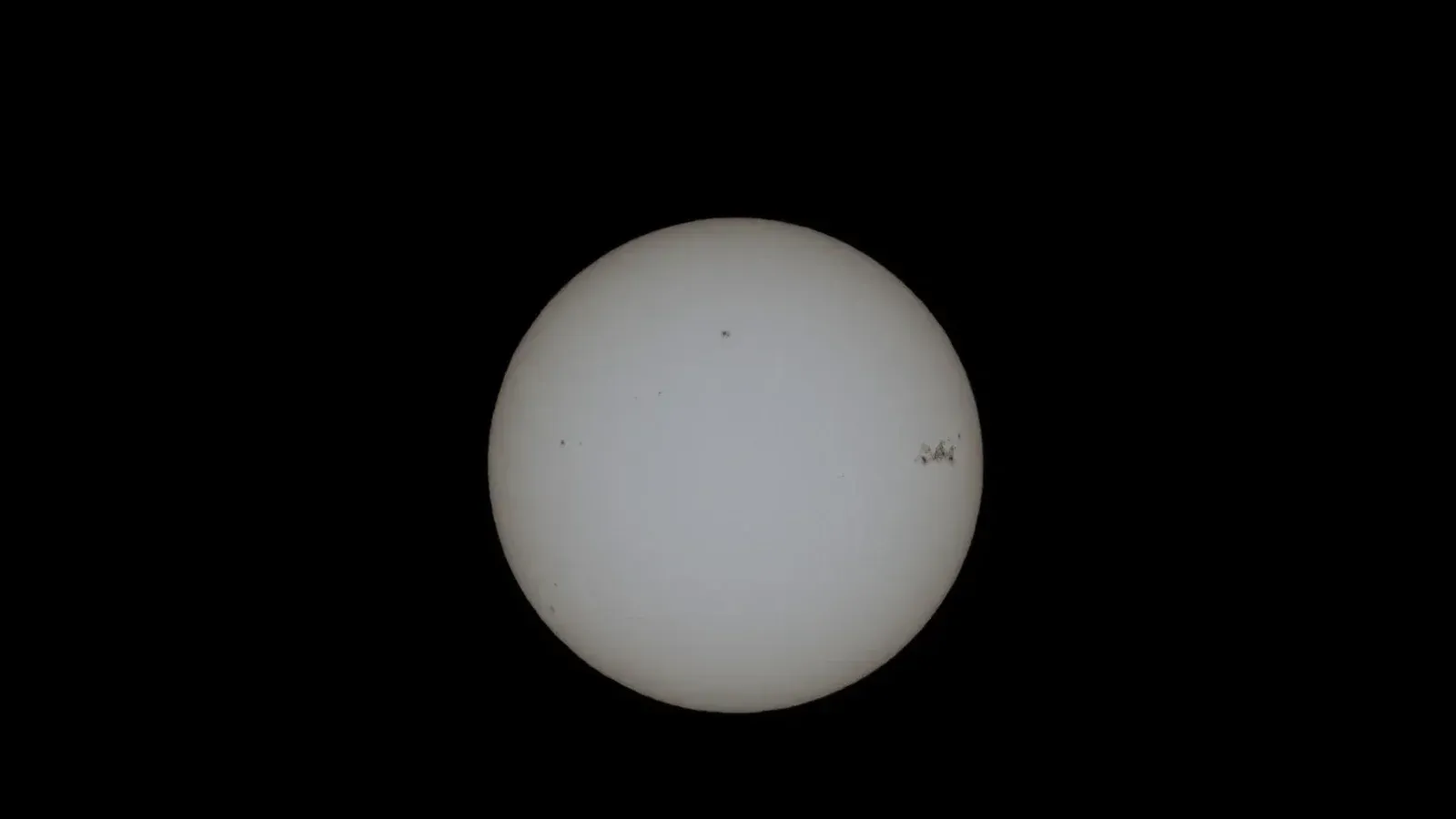 Close-up image of the sun with visible sunspots on a black background.