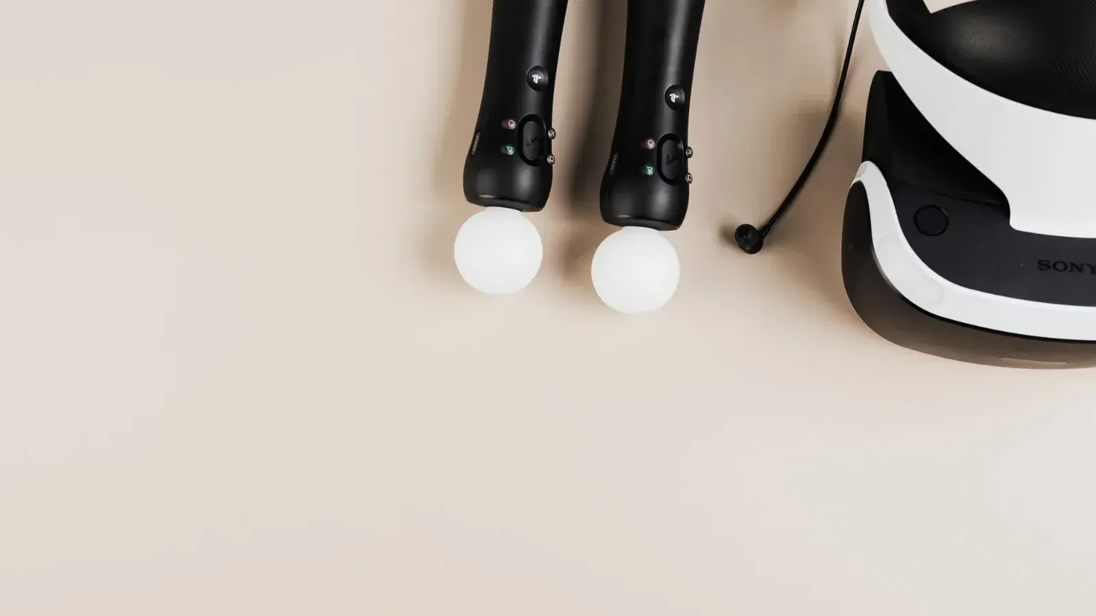 Top view of gaming controllers and VR headset on neutral background.