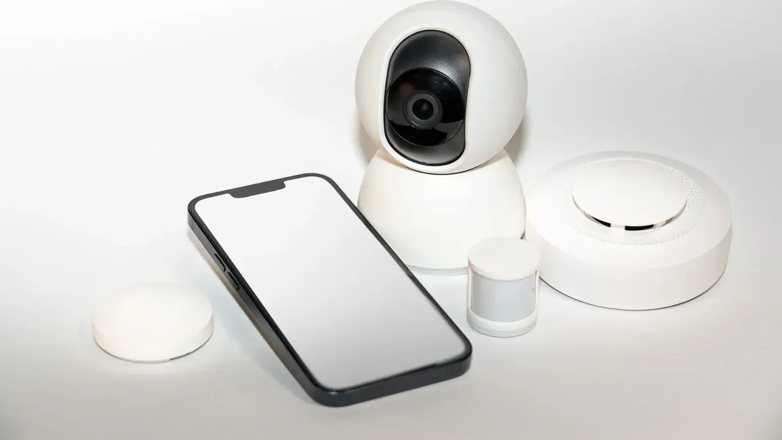 Collection of smart home security gadgets with a smartphone display.