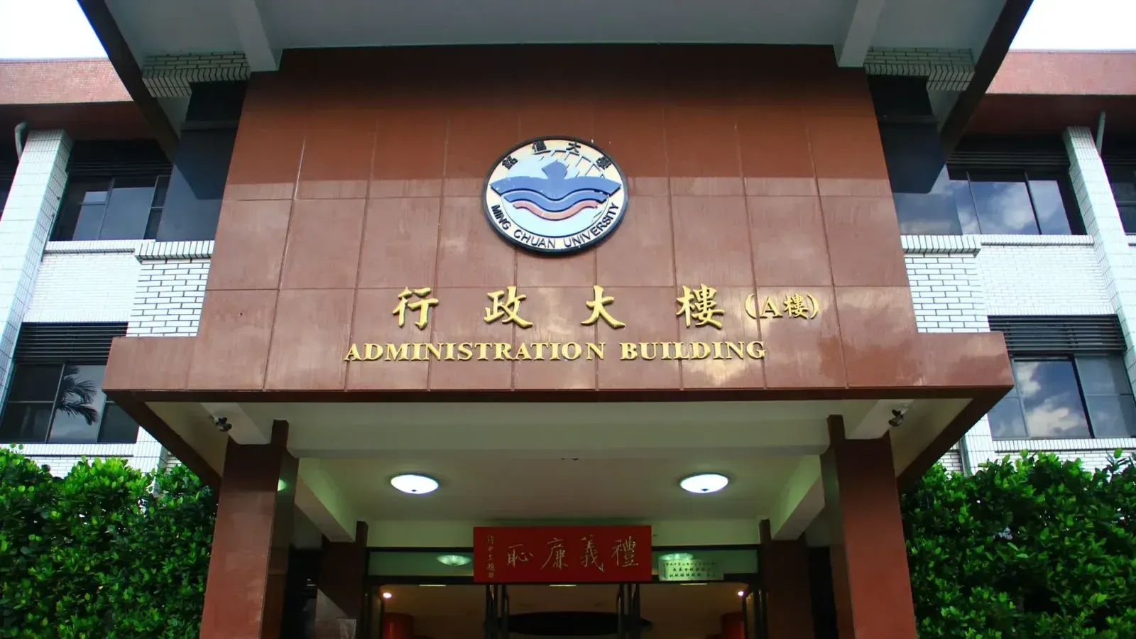 Vista frontal de la entrada del edificio de administración de la Universidad Ming Chuan, que muestra su diseño arquitectónico.