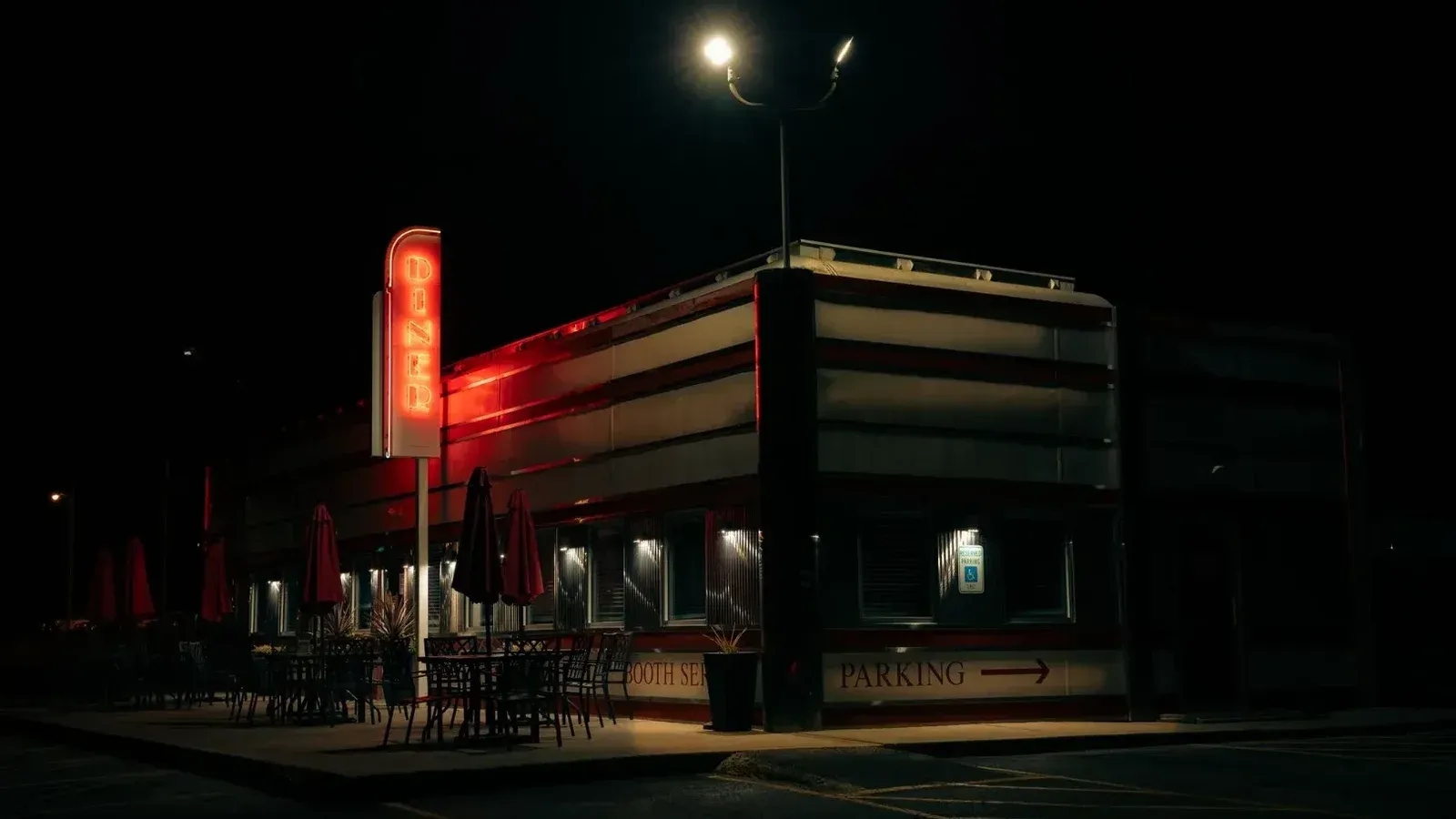 A classic American diner illuminated by a neon sign during the night, creating a nostalgic ambiance.