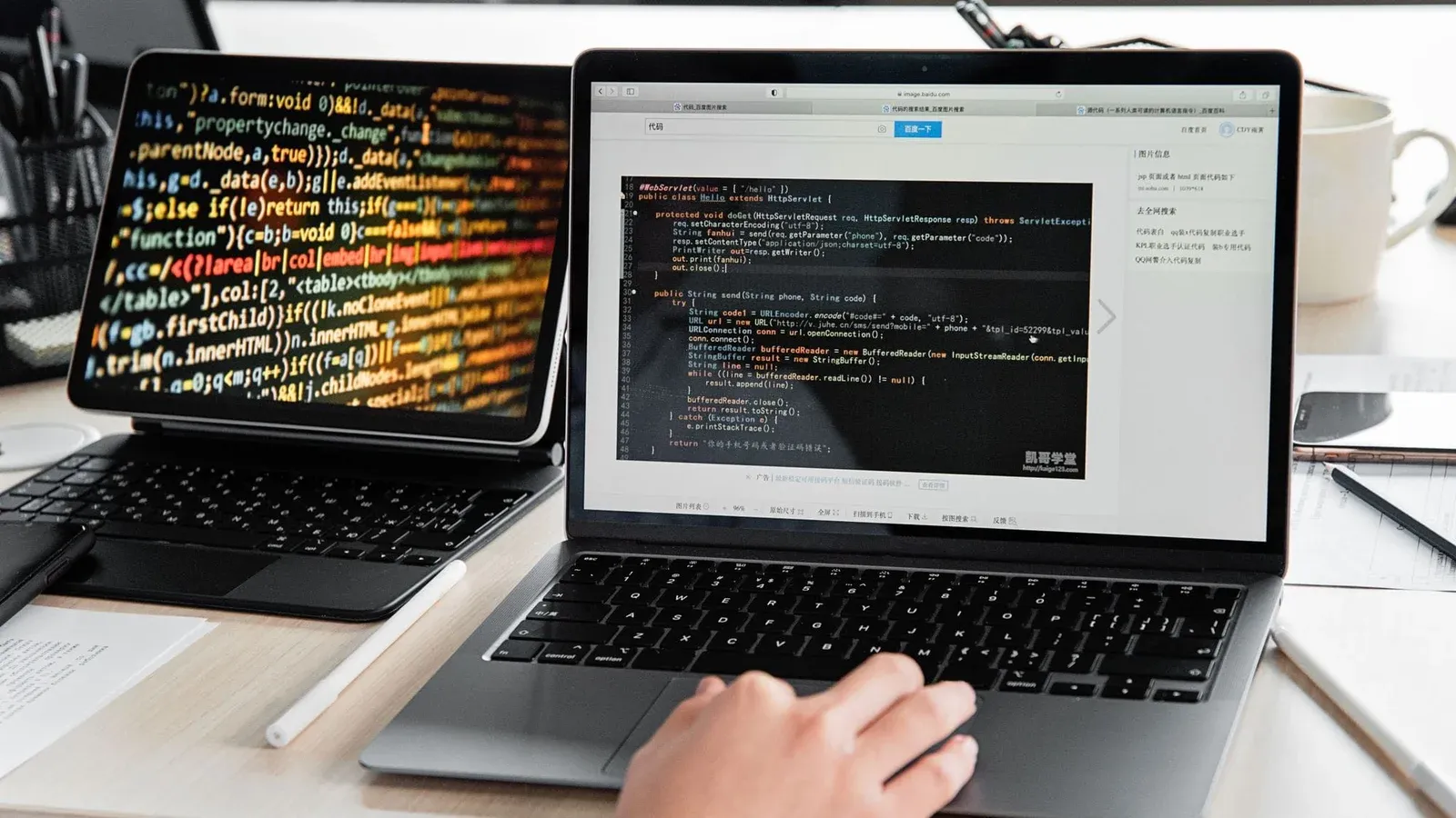 A developer writing code on a laptop, displaying programming scripts in an office environment.