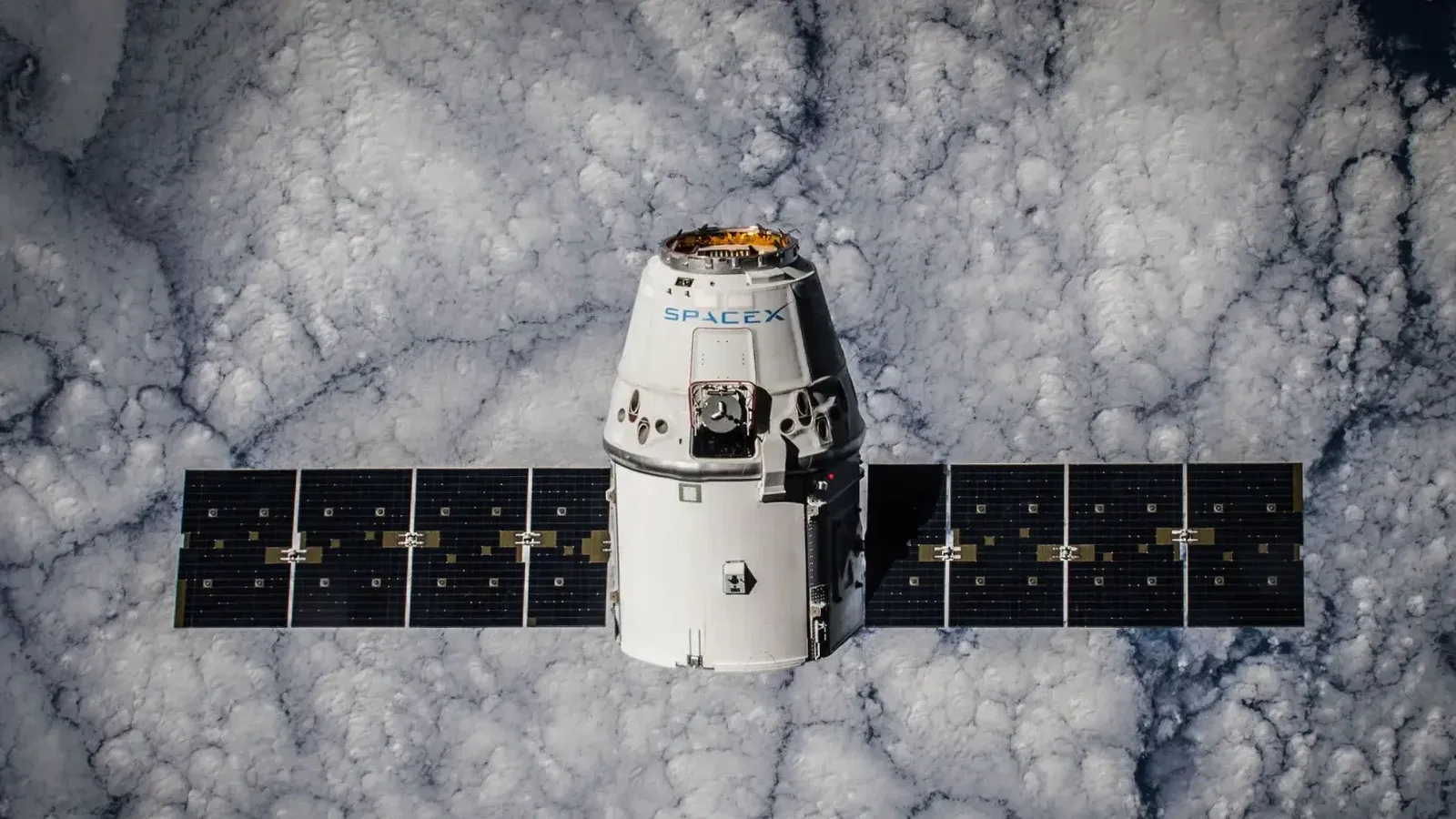 SpaceX Dragon spacecraft in orbit, highlighting advanced space technology with cloud backdrop.