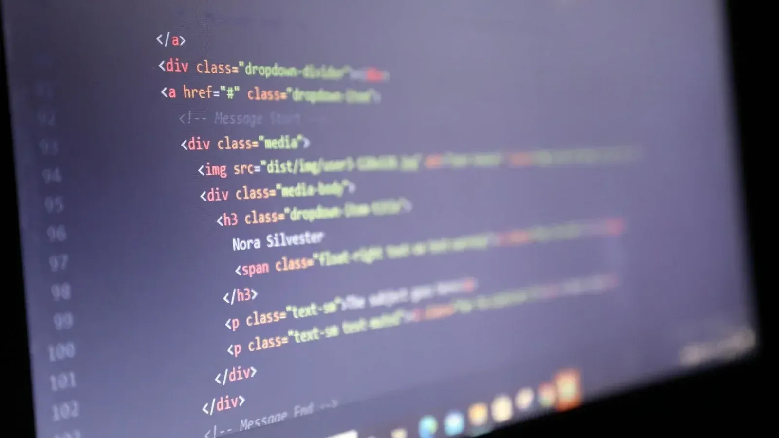 Código HTML iluminado que se muestra en la pantalla de una computadora, vista de cerca.
