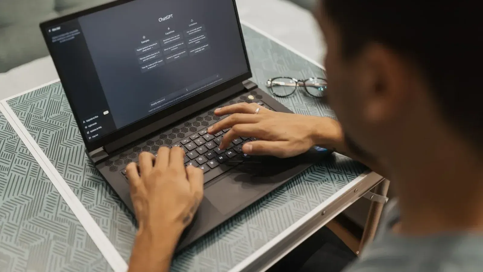 A person using a laptop to interact with AI technology indoors during the day.