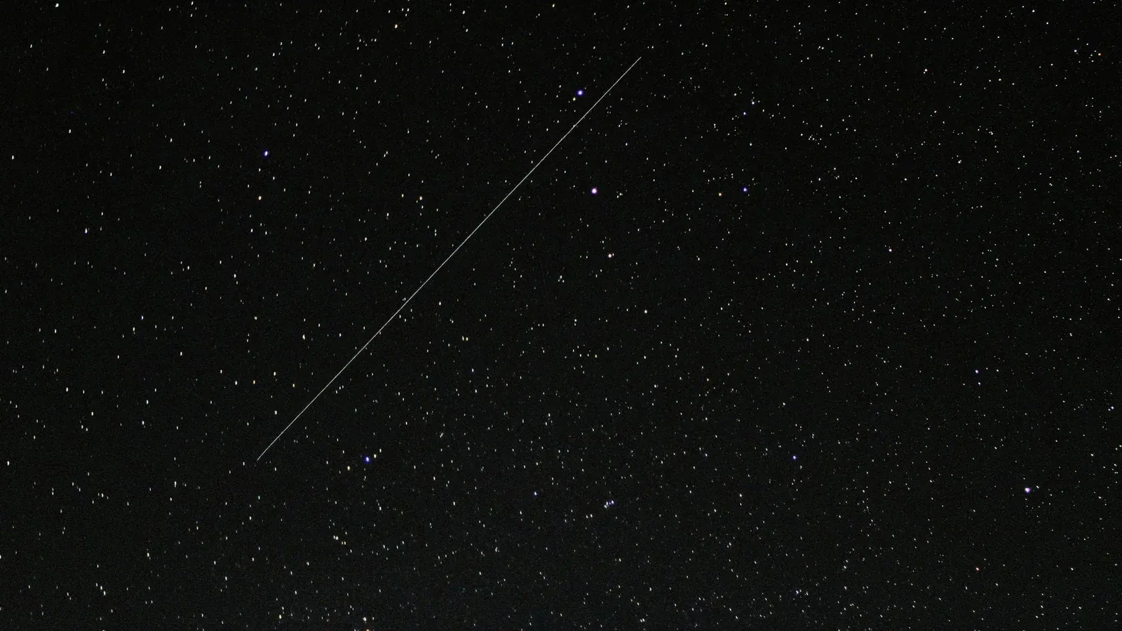 Captivating starry night sky with a visible shooting star streaking across the cosmic backdrop.