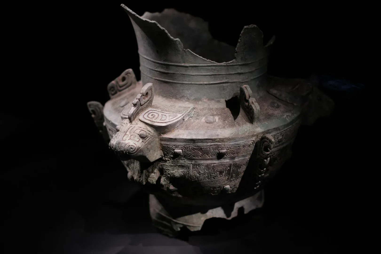 Intricate ancient Chinese bronze vessel with decorative patterns and animal motifs on display.