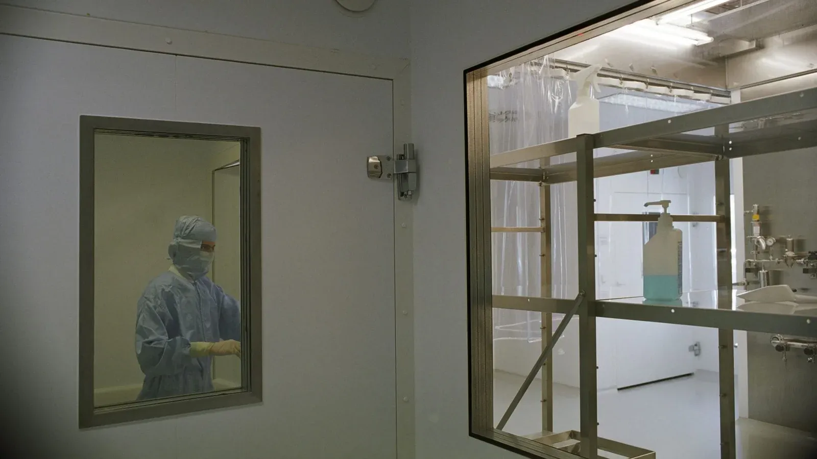 Image of a cleanroom in a medical facility featuring sterile equipment and a person in protective clothing.