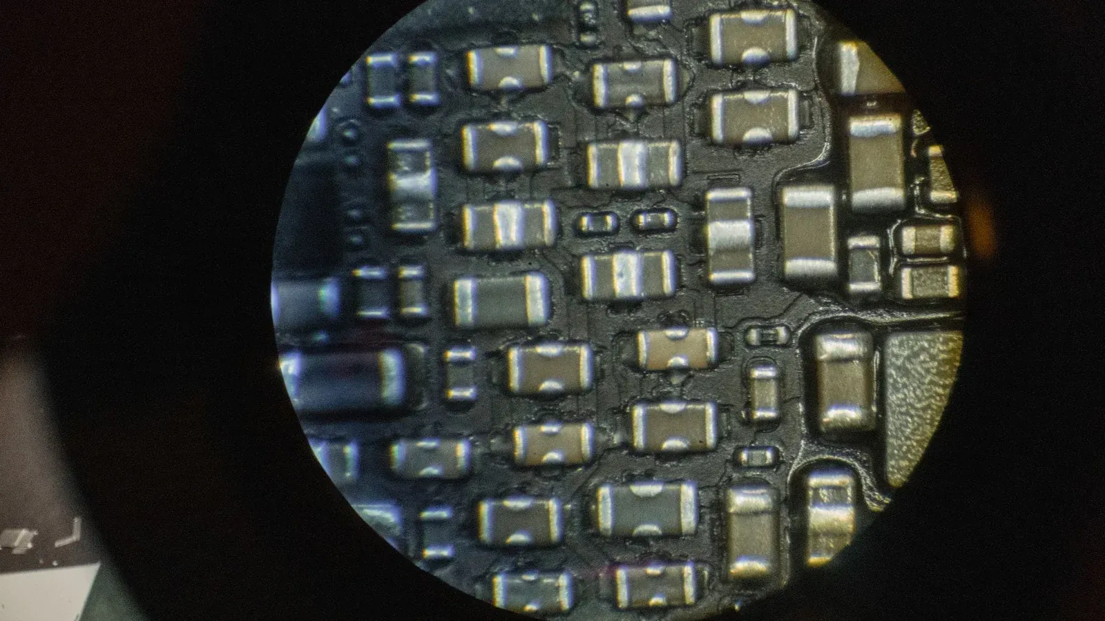 Detailed image of microchip components viewed through a microscope lens.