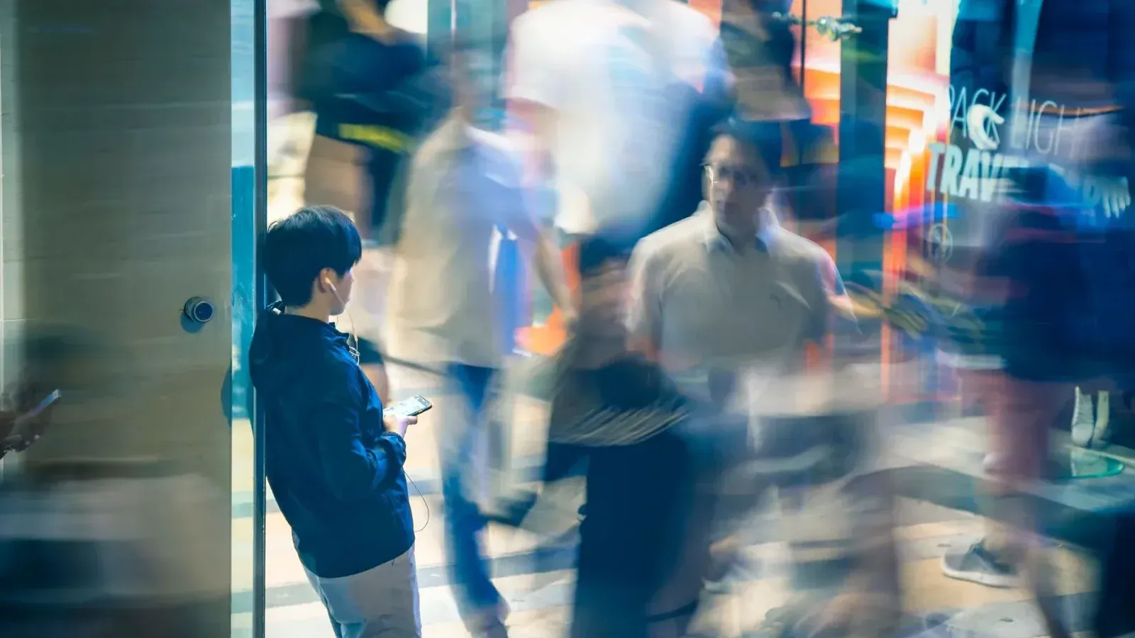 Blurred motion of people walking in Kowloon, Hong Kong, capturing urban life and activity.