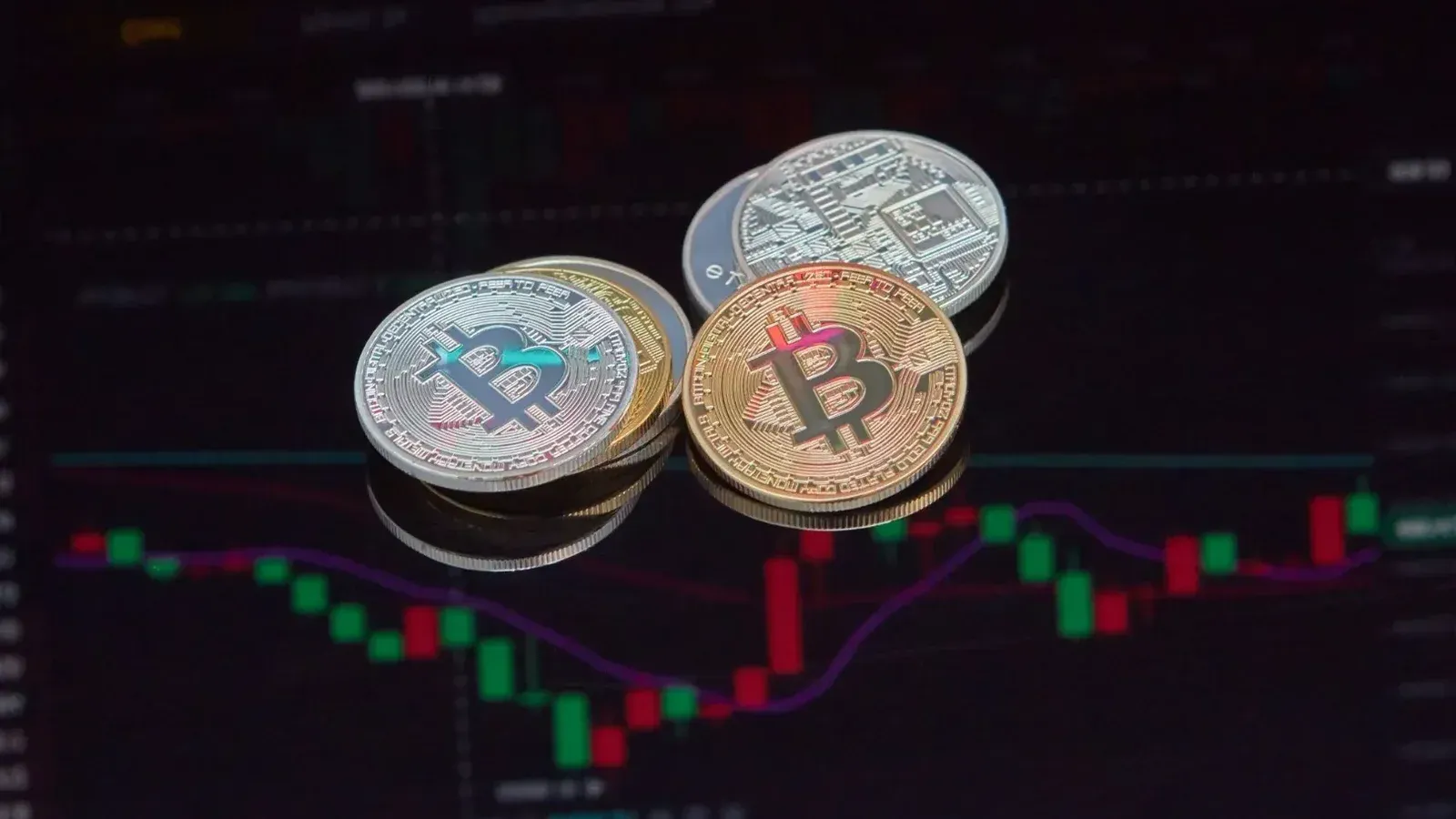 Close-up view of Bitcoin coins on a stock market chart background representing cryptocurrency trading.