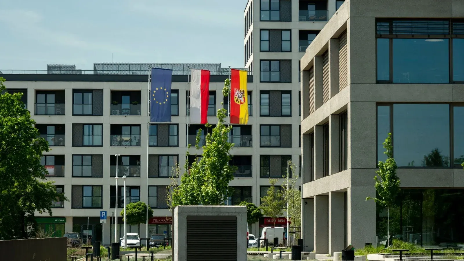 Contemporary architecture in Wrocław, Poland with flags of EU, Poland, and Wrocław.