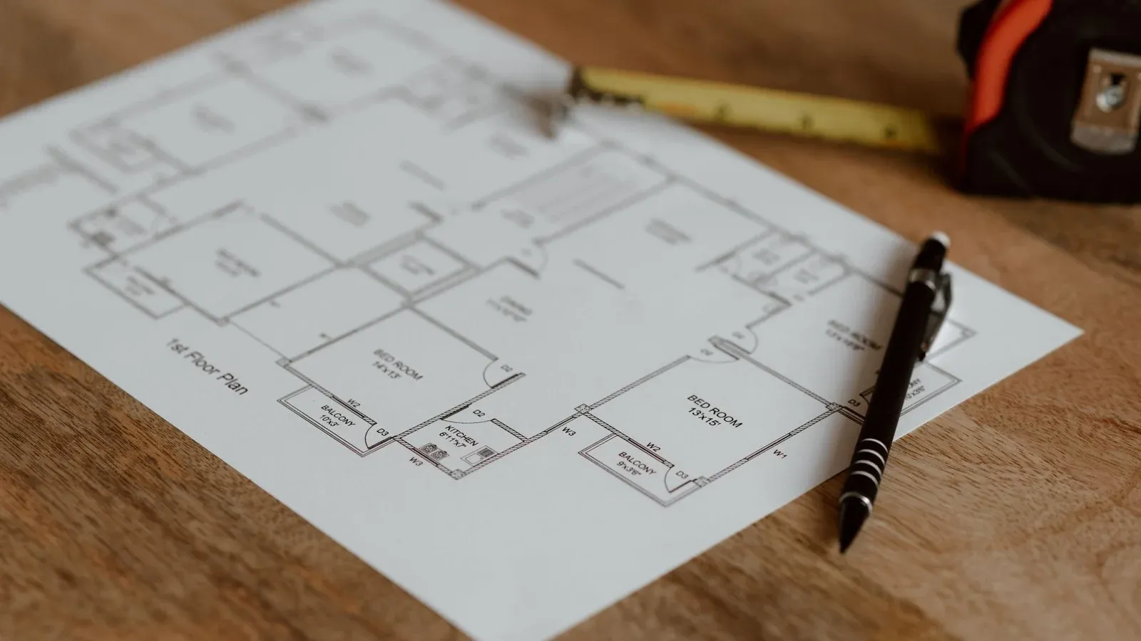 Architecture scheme of floor on paper placed on wooden surface near pen and ruler in room during renovation work in building