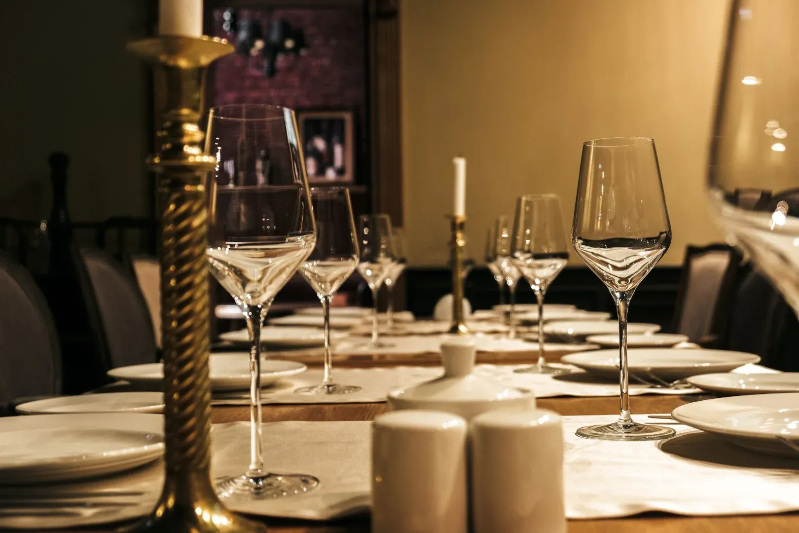 Luxurious table setup with wine glasses and candle holders in an elegant dining setting.
