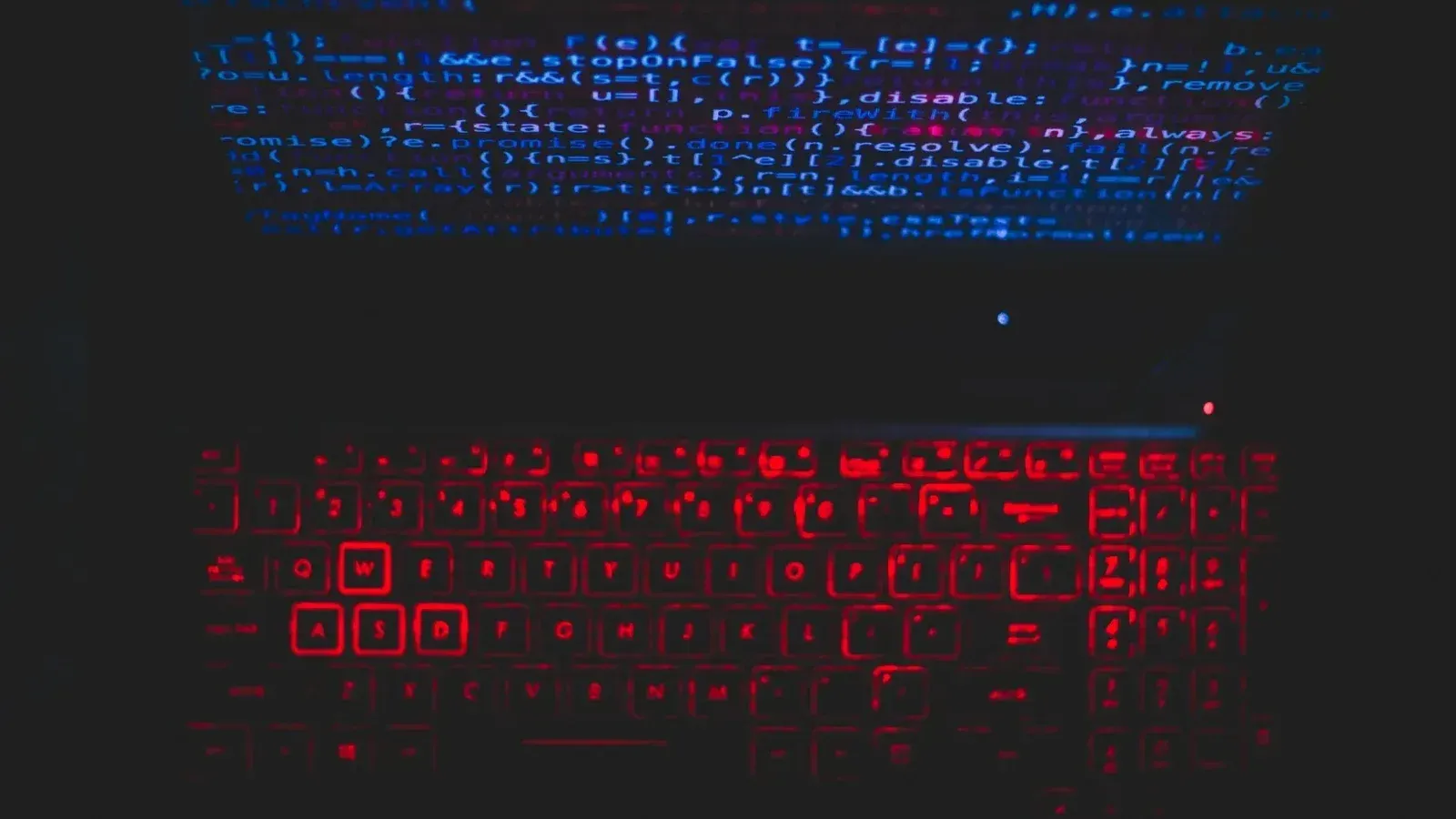 Dark-themed laptop setup with a red glowing keyboard and code on screen, ideal for tech enthusiasts.