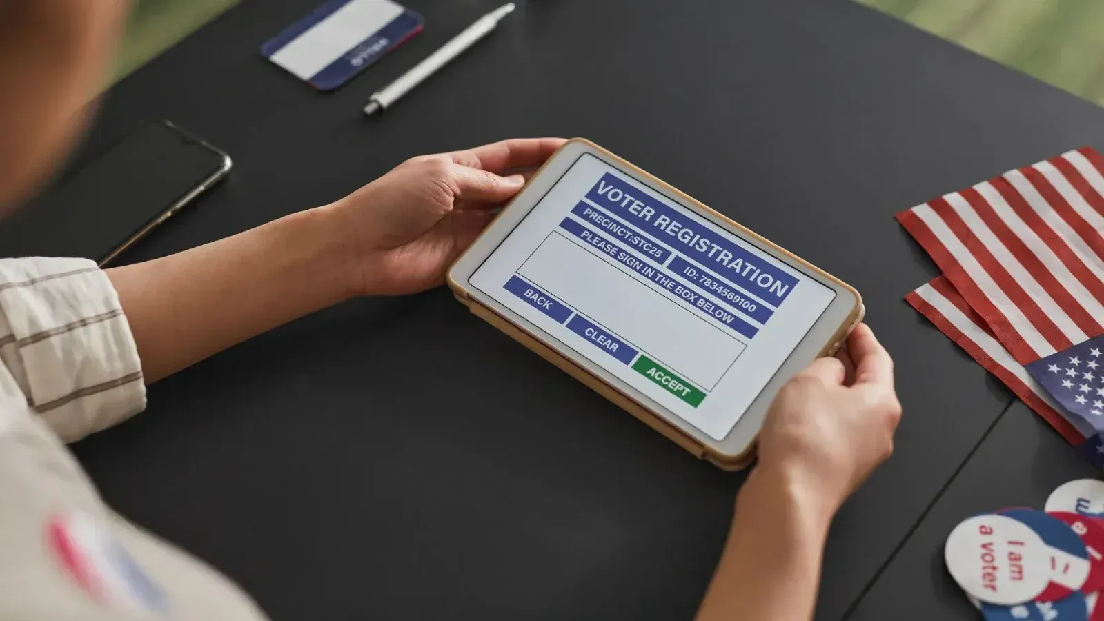 A person using a tablet for voter registration, highlighting digital voting processes.