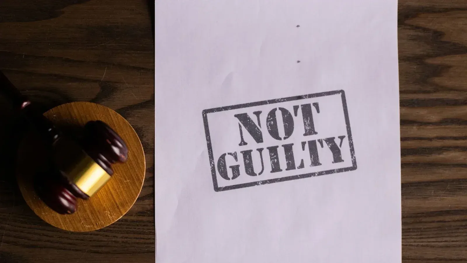 A courtroom document labeled 'Not Guilty' beside a gavel symbolizes justice.