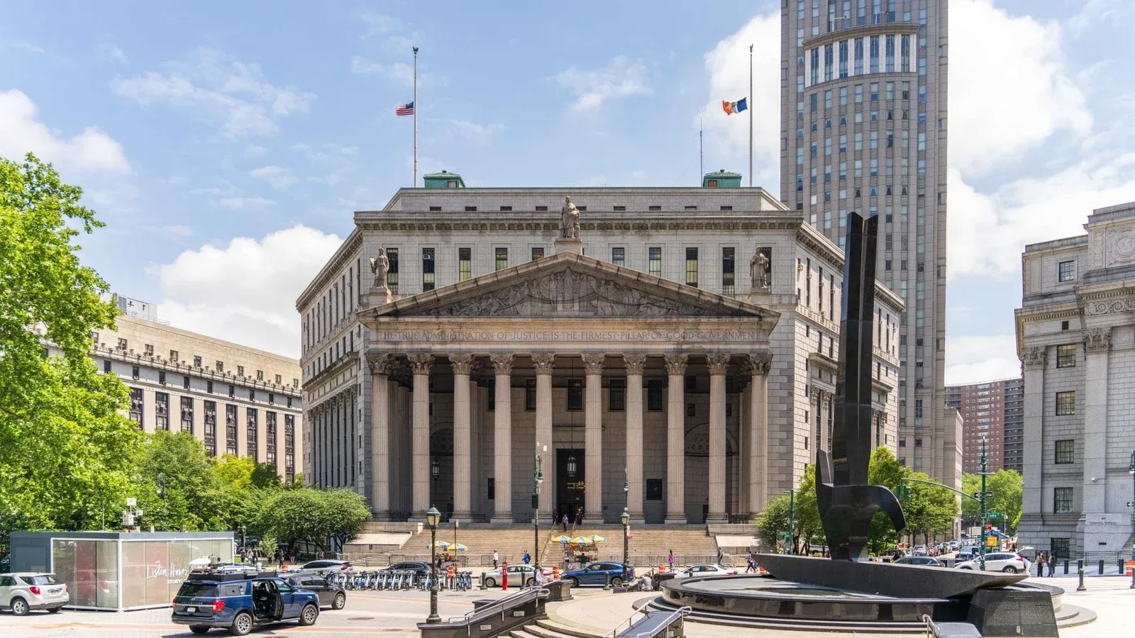 View of the historic New York County Courthouse with clear skies and cityscape.