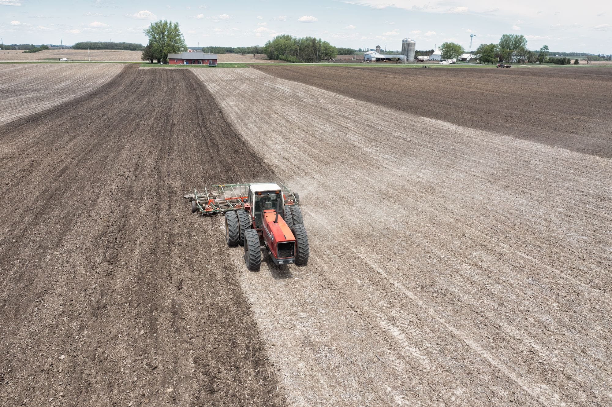 Aerial shot of a tractor plowing a large agricultural field in Minnesota, USA.