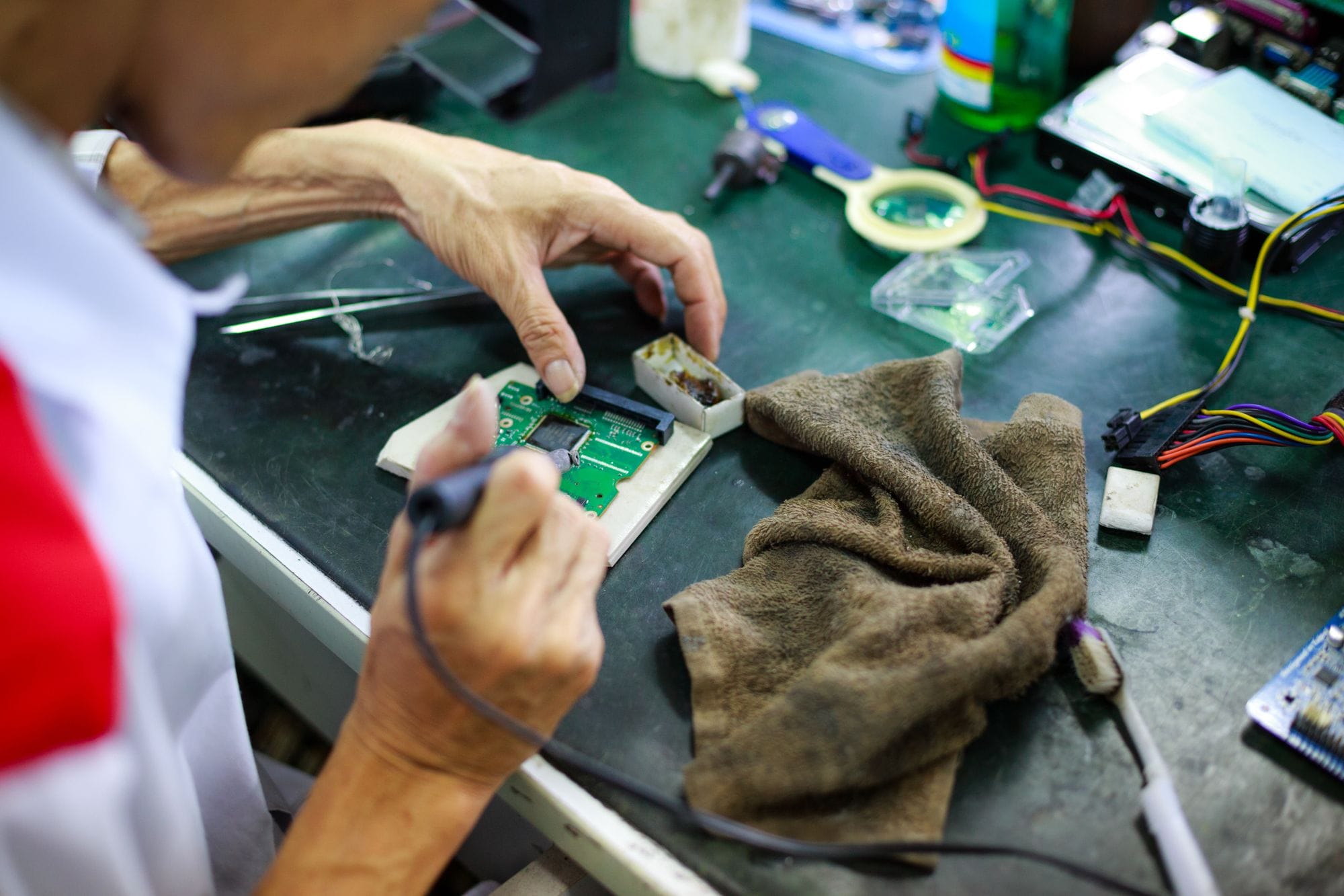 Technician expertly repairing a circuit board, showcasing skill and precision.