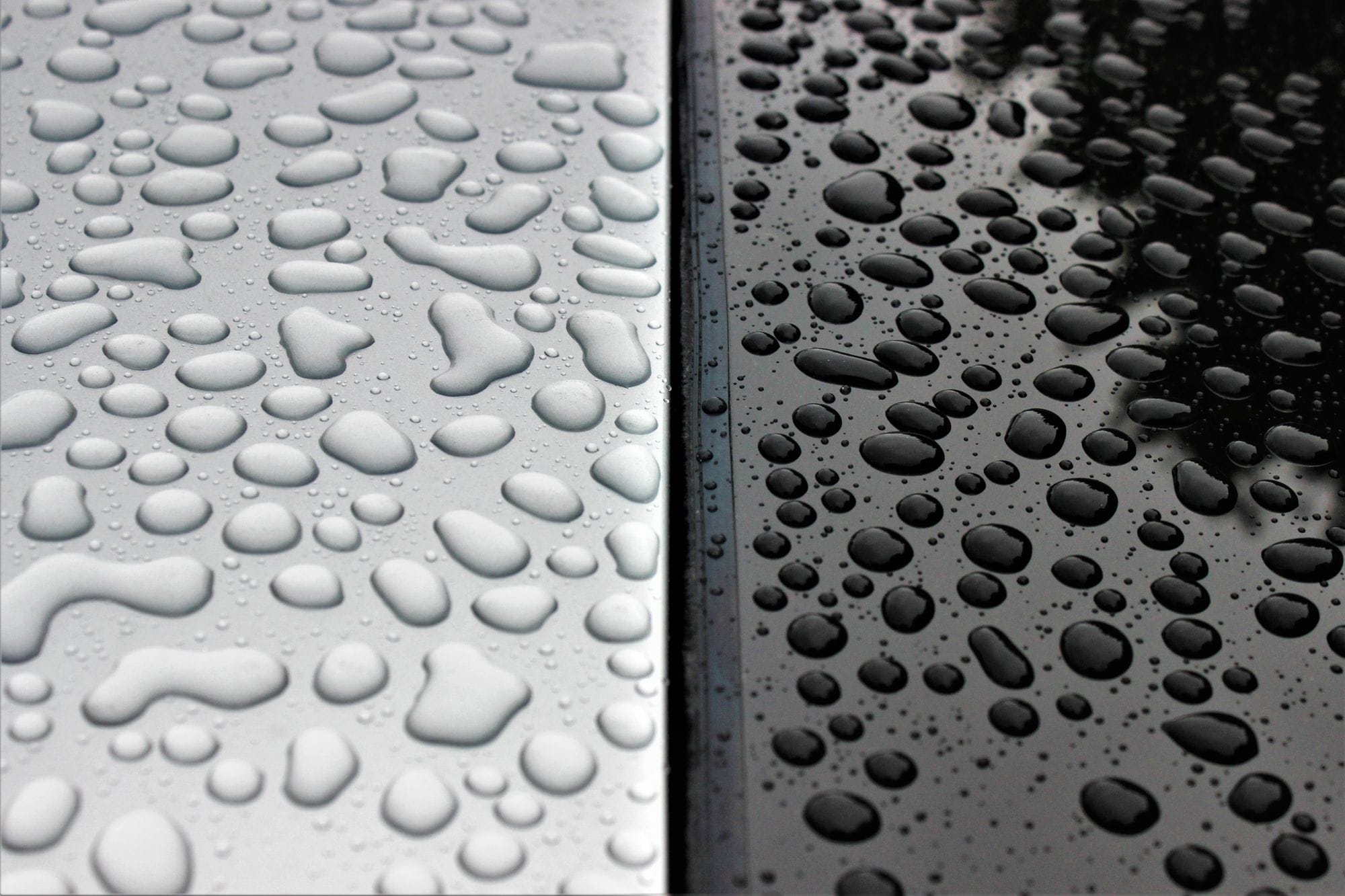Detailed shot of raindrops on contrasting black and white surfaces.