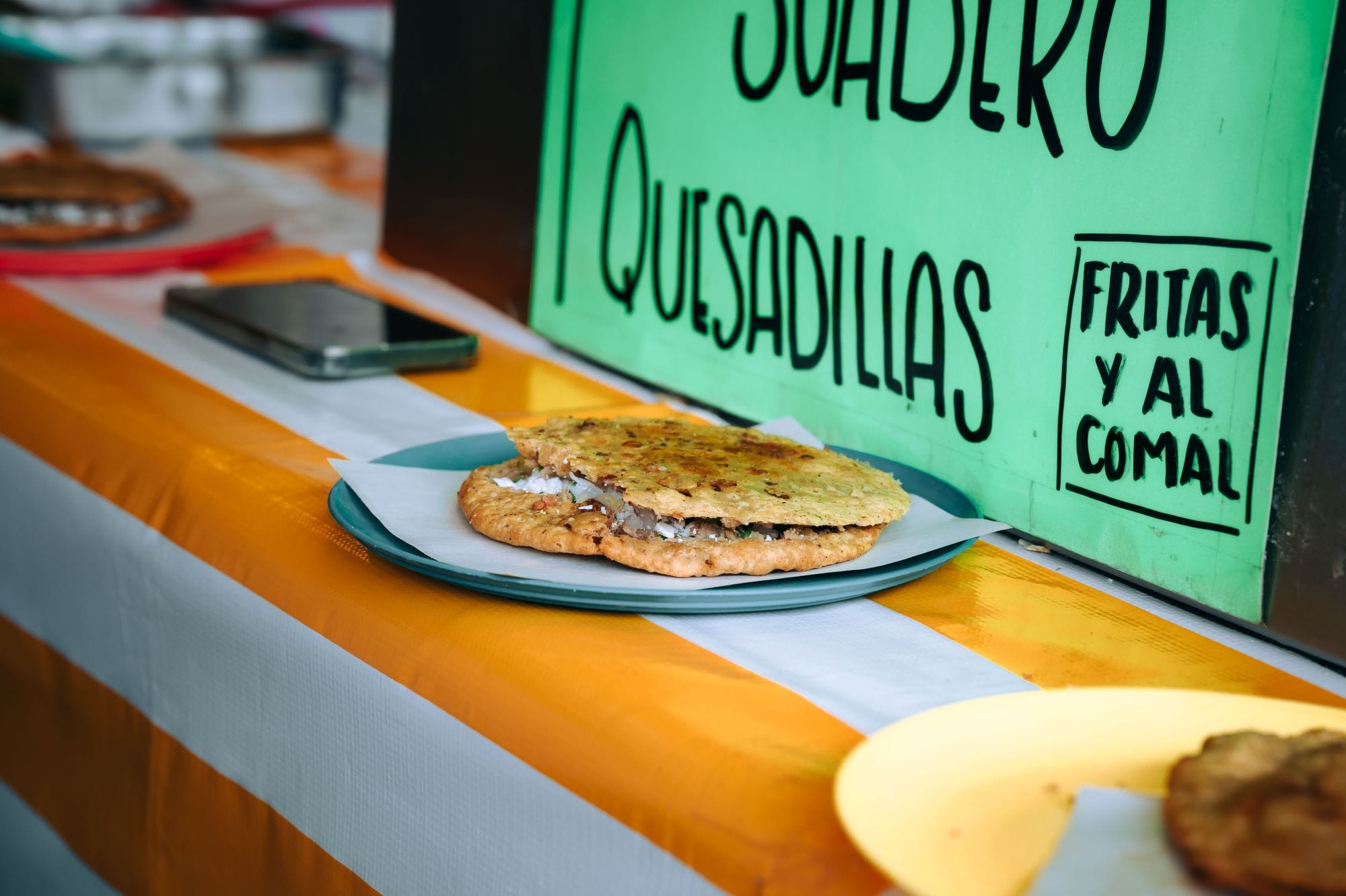 Delicious Mexican quesadilla served on a plate at a street food stand in Mexico City.