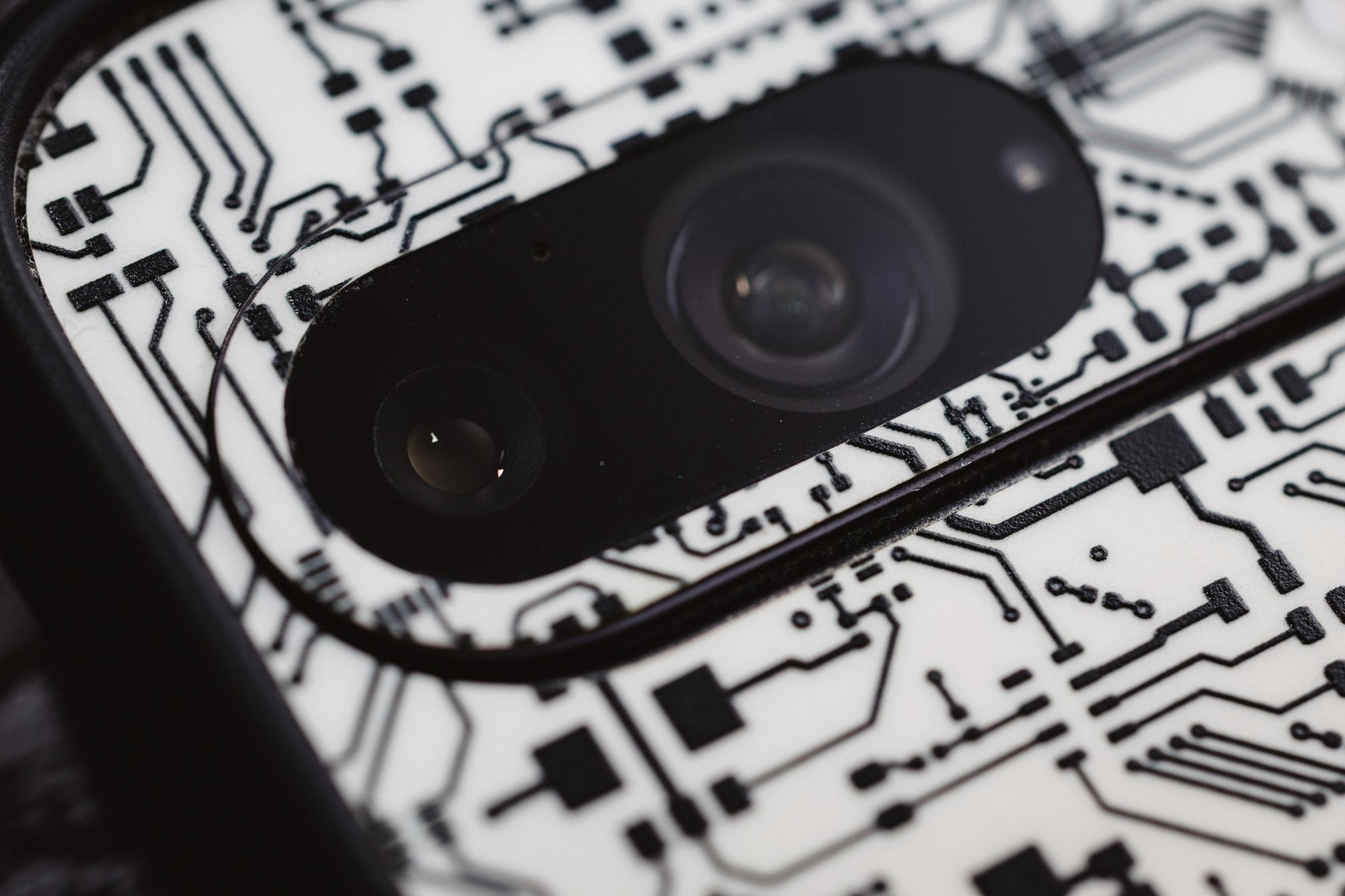 Macro shot of an electronic circuit design around a smartphone camera lens, showing intricate details.