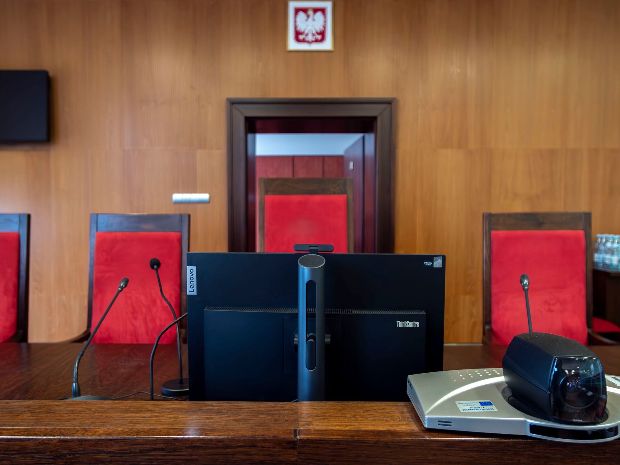 Modern courtroom interior in Wrocław, Poland featuring judge's bench and red seating.