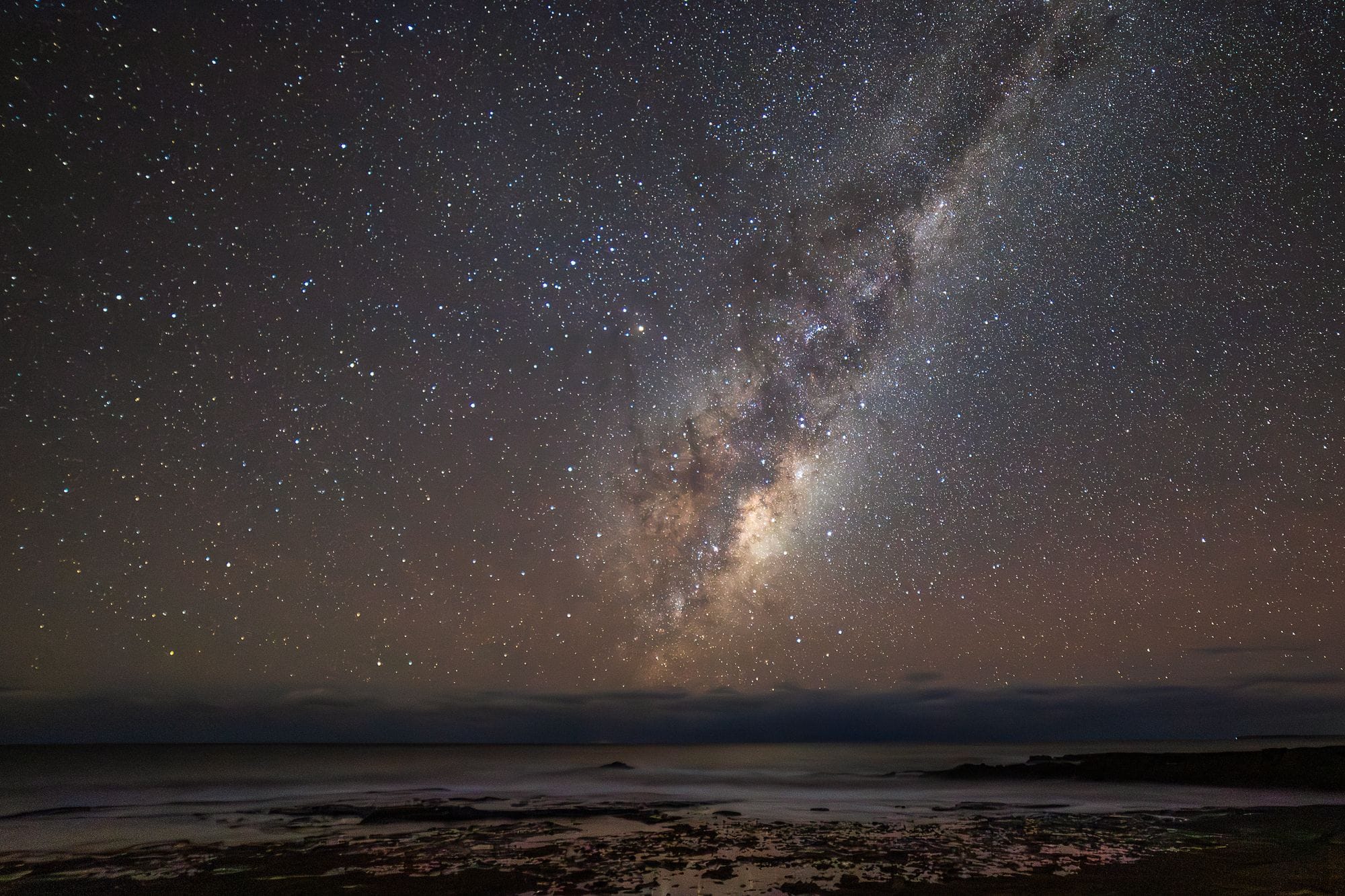 Dazzling view of the Milky Way galaxy over the serene Campbelltown beach at night.