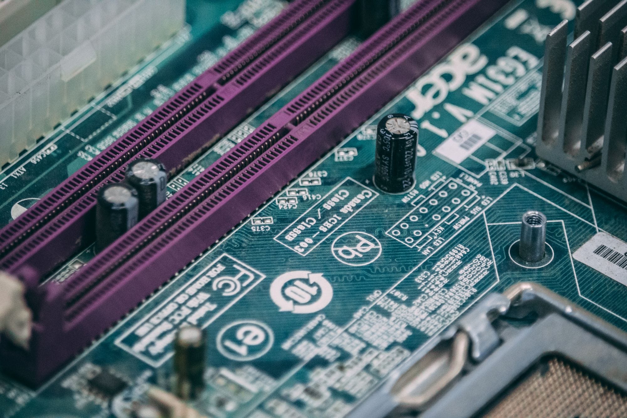 Detailed close-up of a green electronic circuit board with visible components and slots.
