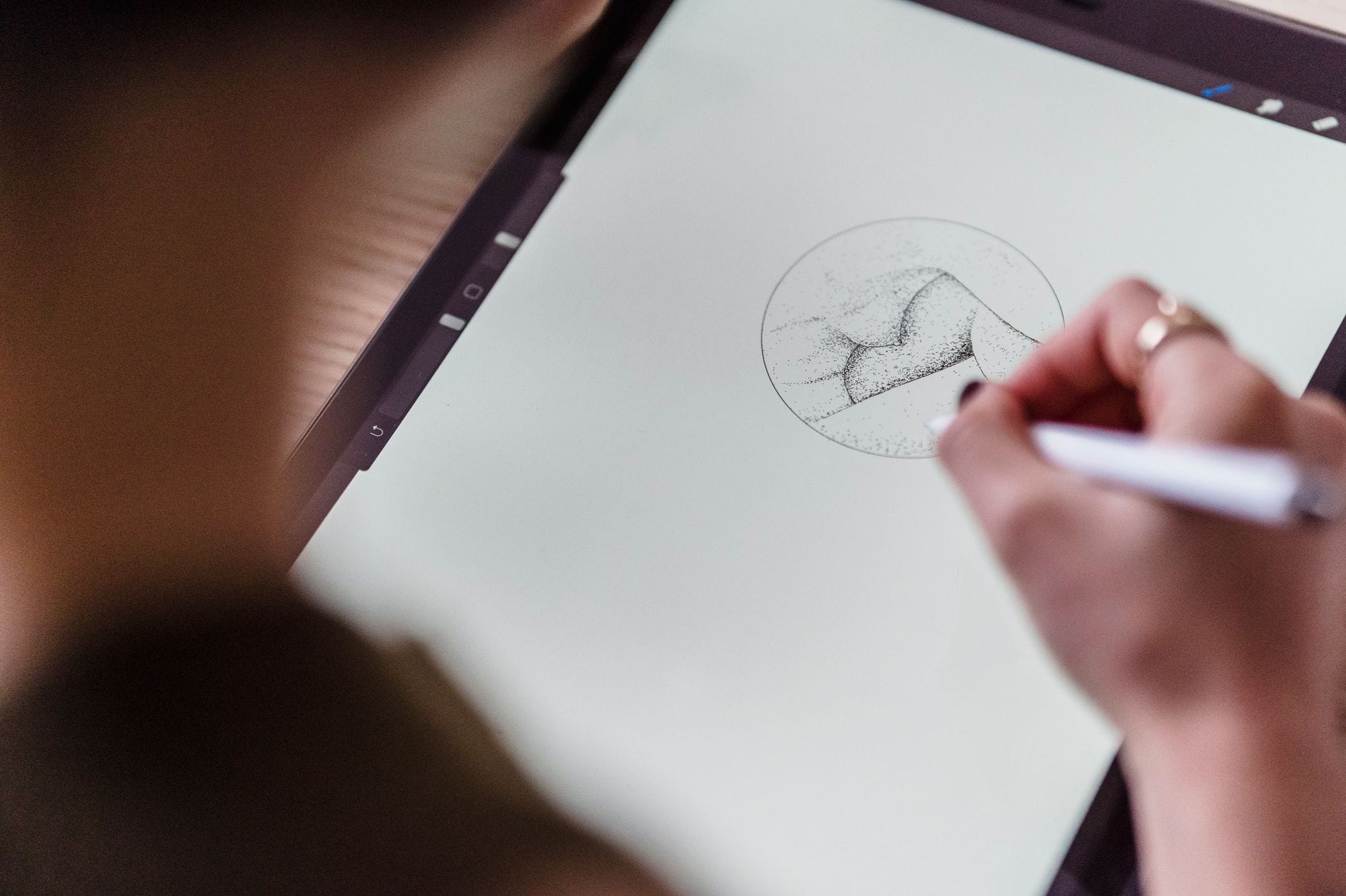 From above of crop anonymous artist with stylus in hand drawing creative sketch on graphics tablet