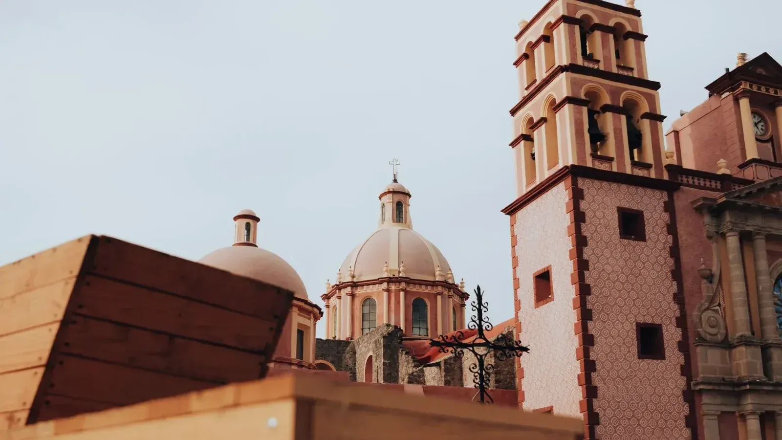 View of neoclassical church domes and tower in Tequisquiapan, Mexico, against a clear sky.
