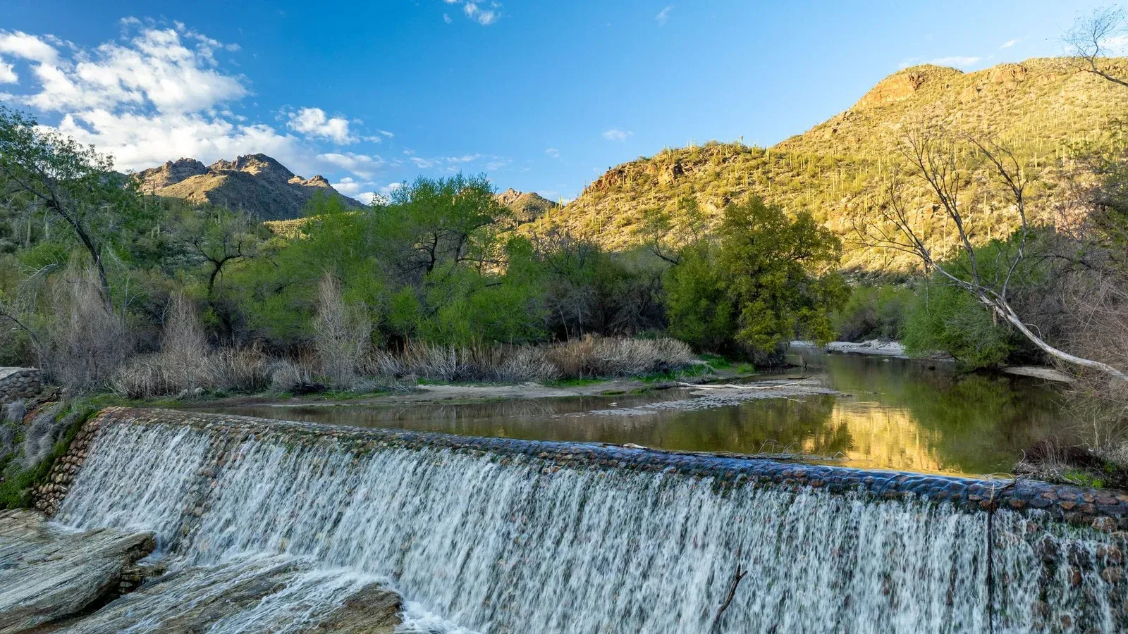 Serene view of Sabino Canyon dam waterfall and mountains in Tucson, Arizona.