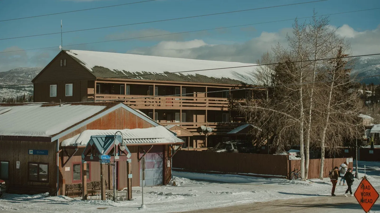 Winter scene with snow-covered rustic buildings and mountains in Colorado.