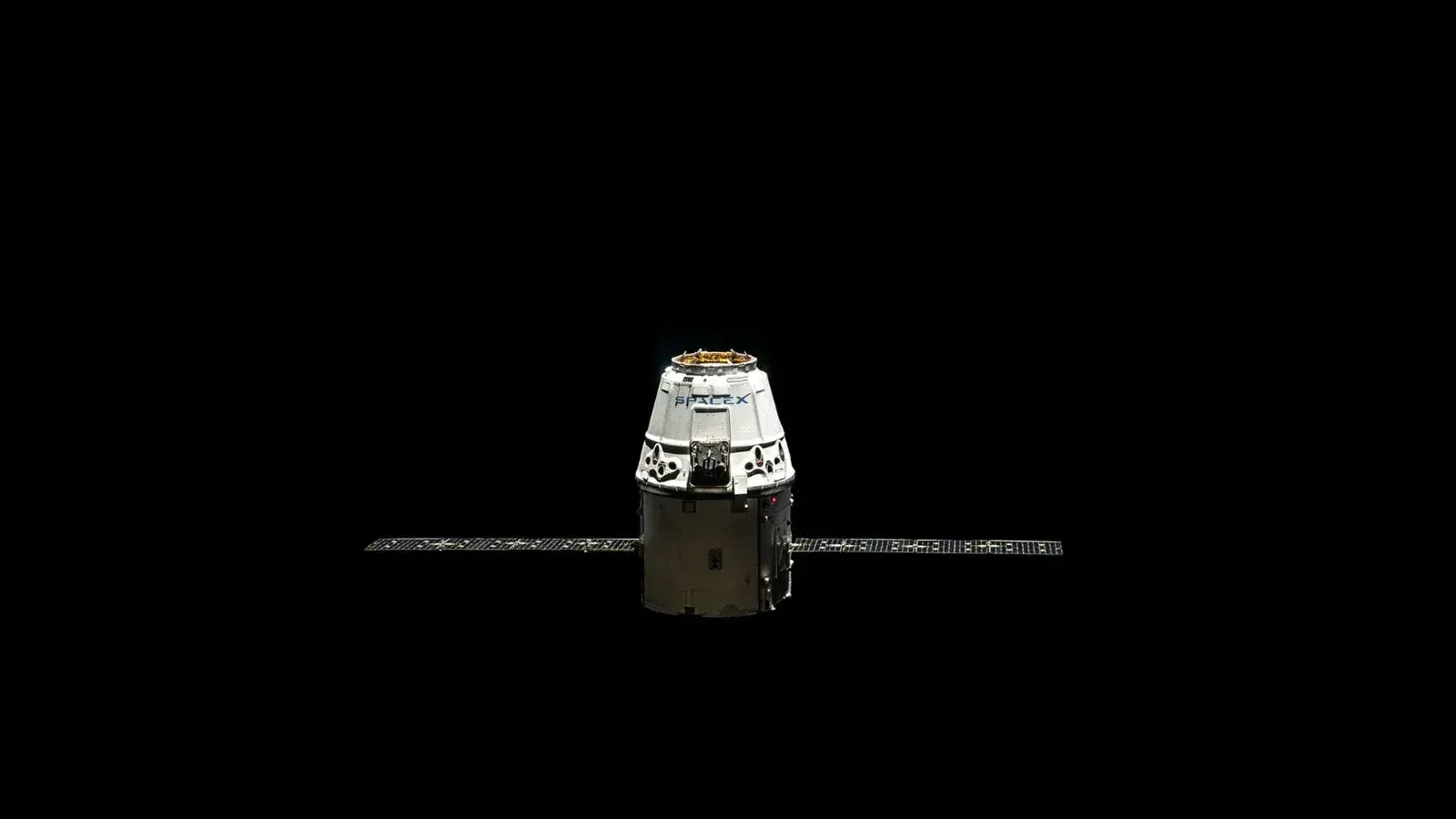 A SpaceX Dragon capsule orbited against the dark vastness of outer space.