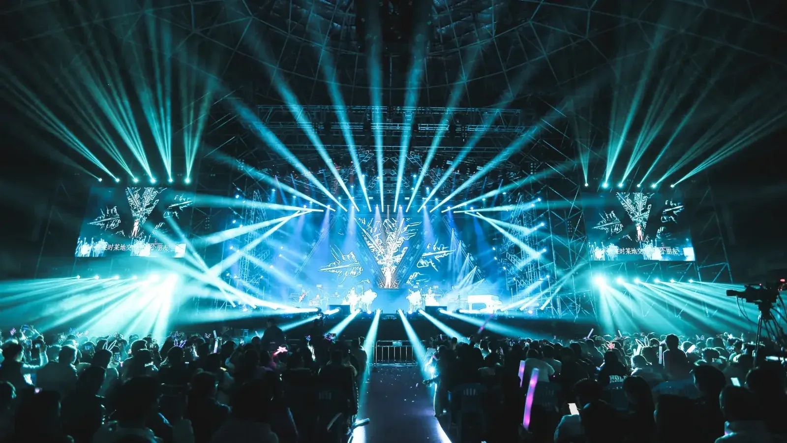 Escena animada de conciertos con deslumbrantes luces de escenario y una gran multitud entusiasta disfrutando del evento.